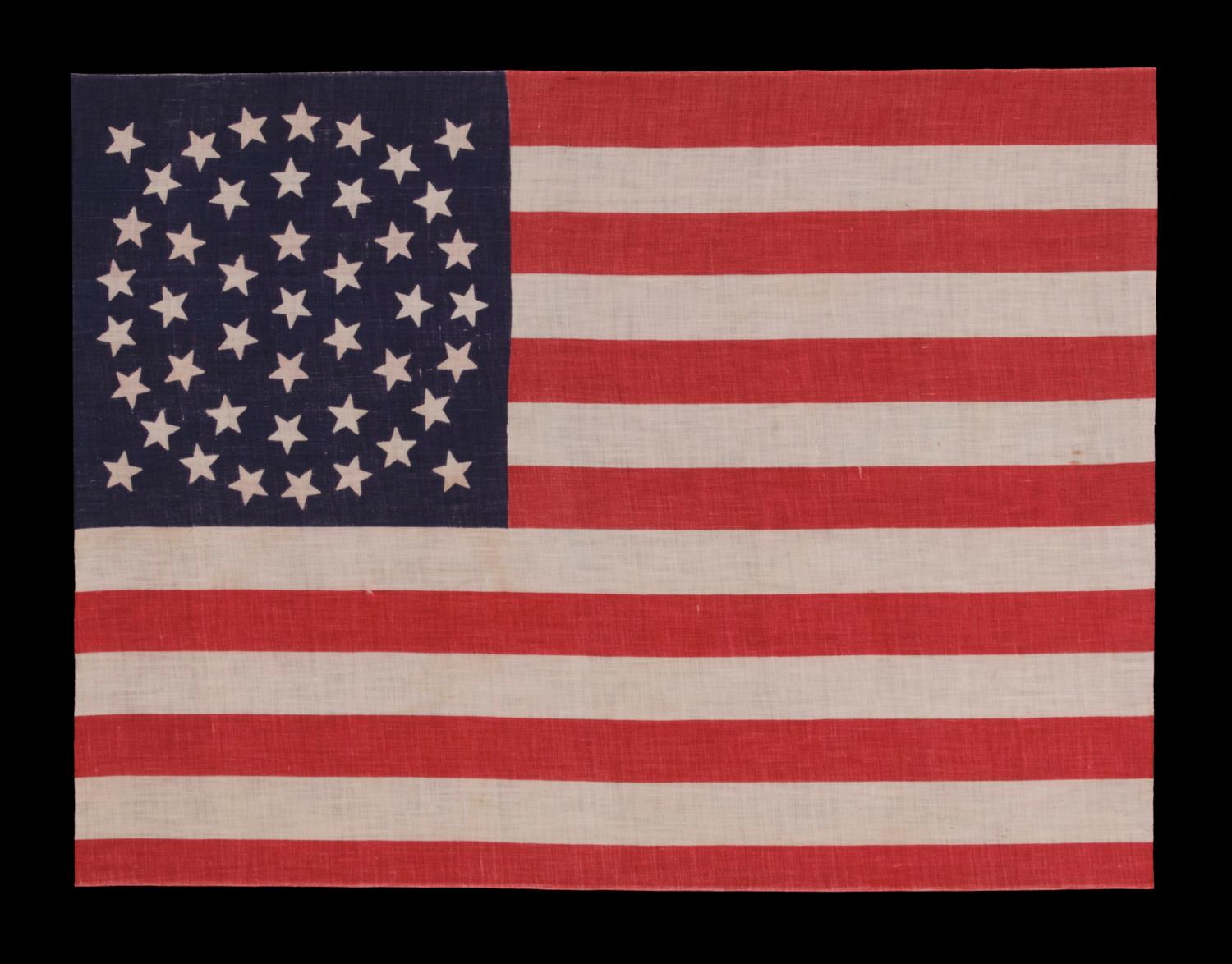 44 STARS ON A LARGE SCALE PARADE FLAG, WYOMING STATEHOOD, 1890-1896, RARE IN THIS PERIOD WITH A WREATH CONFIGURATION 

44 star American parade flag with triple wreath medallion star configuration, printed on cotton. This highly desired star pattern