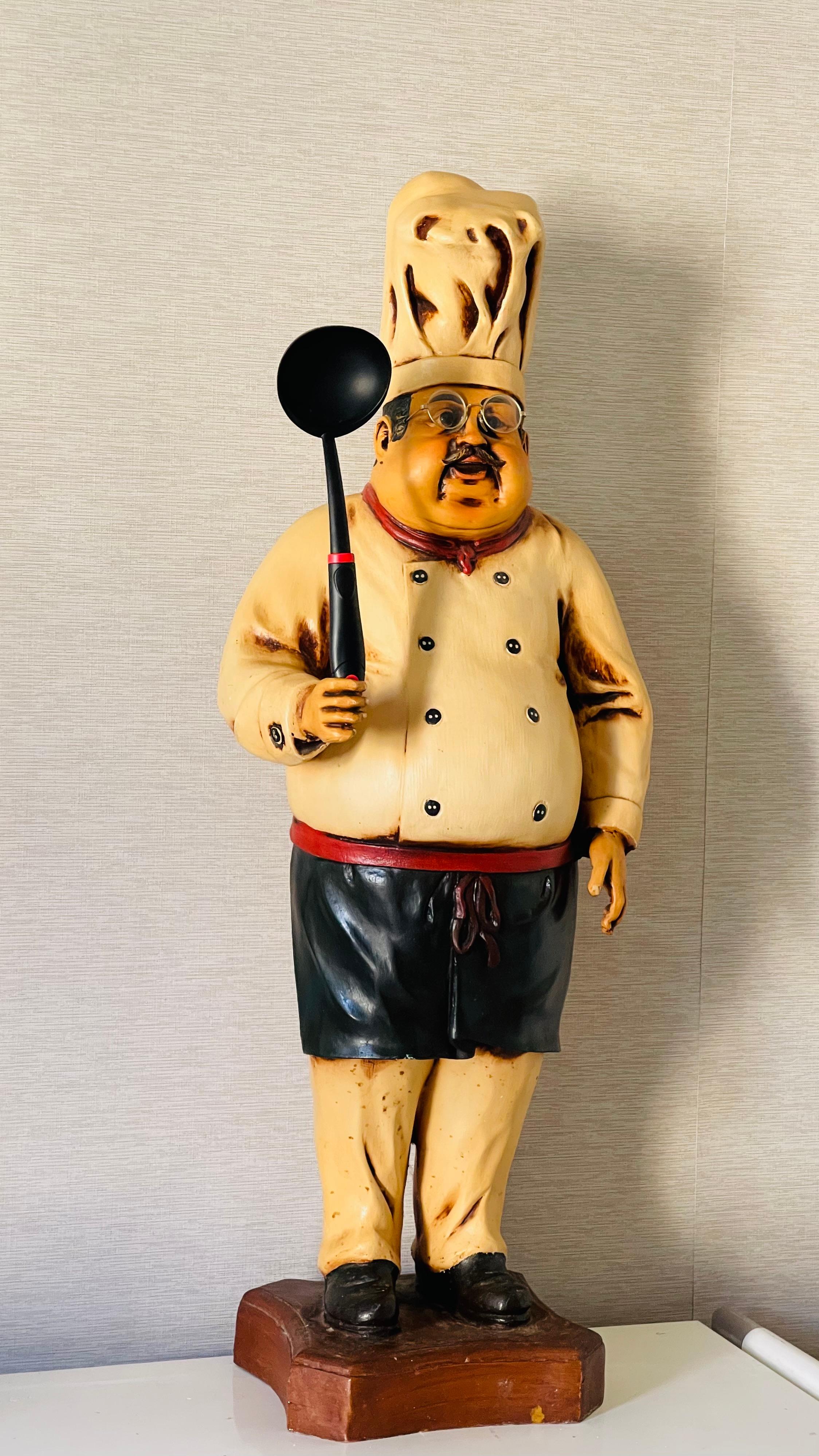 Figura stravagante di uno chef francese per l'insegna di un ristorante di salumi.