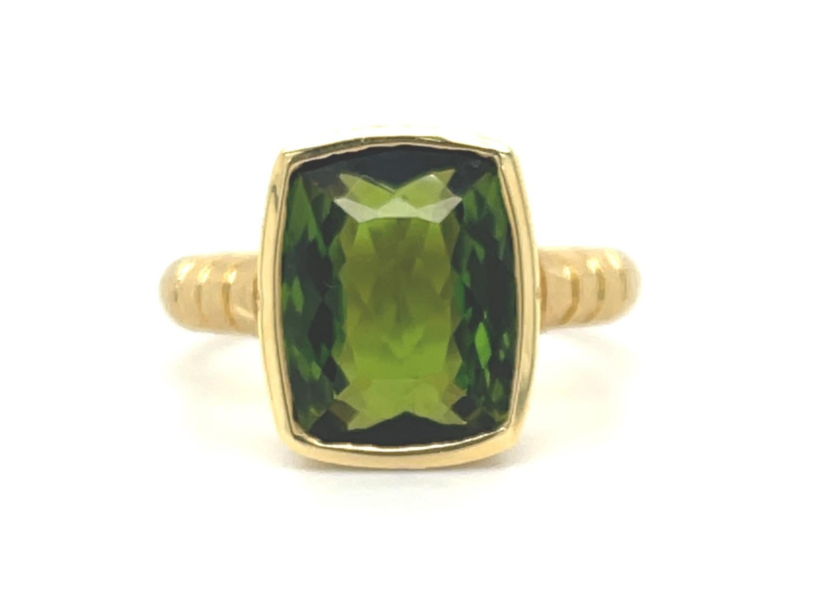 This beautifully designed ring features a 4.40 carat cushion-cut green tourmaline set in a handmade 18k yellow gold bezel with sparkling diamond accents. The center stone has bright, medium green color and 