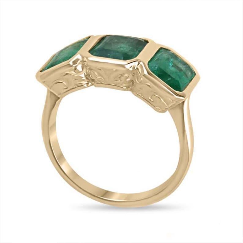 Un capolavoro di eleganza senza tempo e di maestria artigianale, questo anello trilogy con castone da 4,40 carati e taglio smeraldo incastonato è una vera e propria testimonianza dei momenti più significativi della vita. Ognuno dei tre smeraldi,