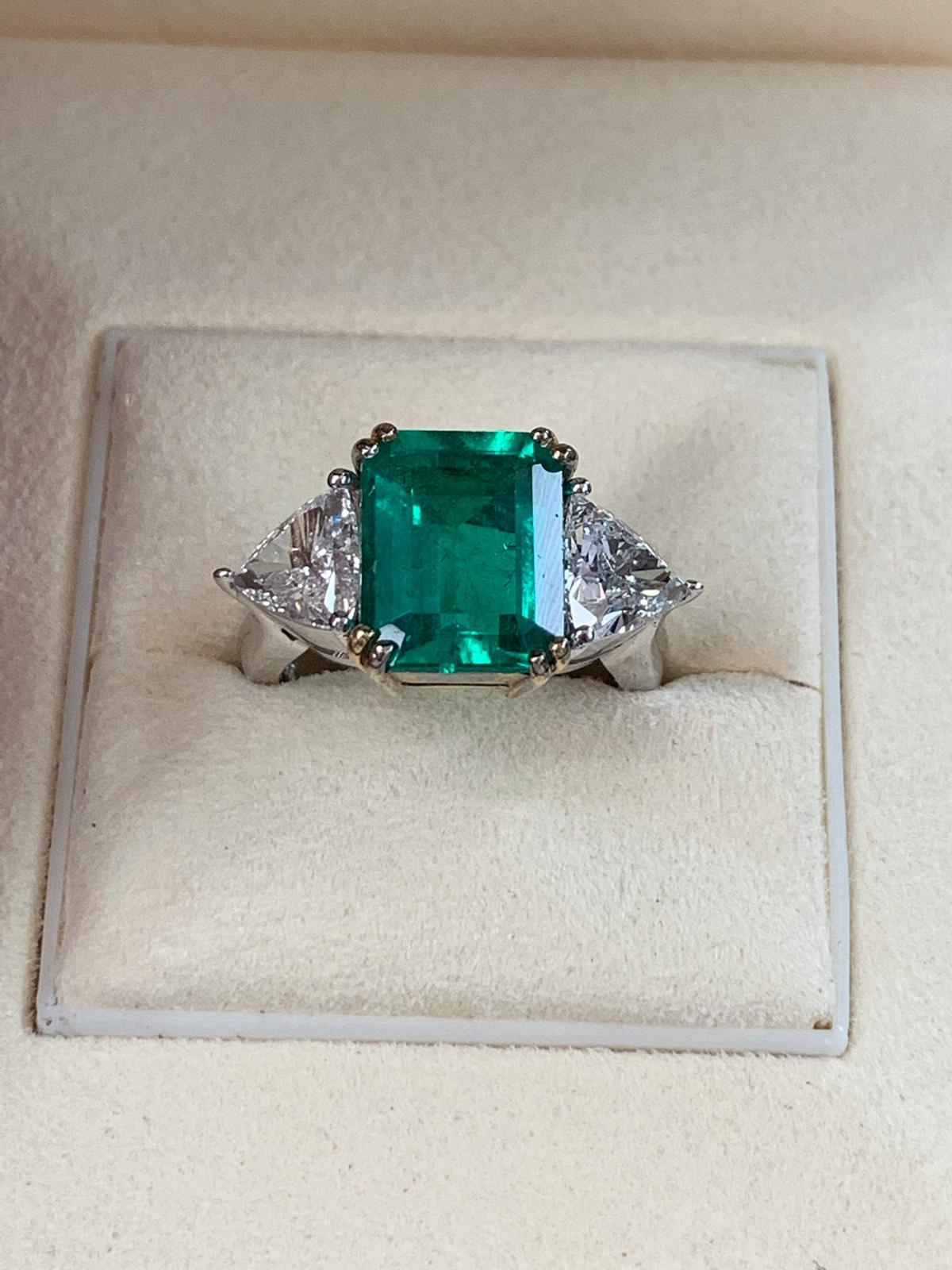 Beautiful 4.42 carats of Colombian Emerald, surrounded by 2 white trillion cut diamond 1.60 total carats.Set on 4 prong 18k white gold.