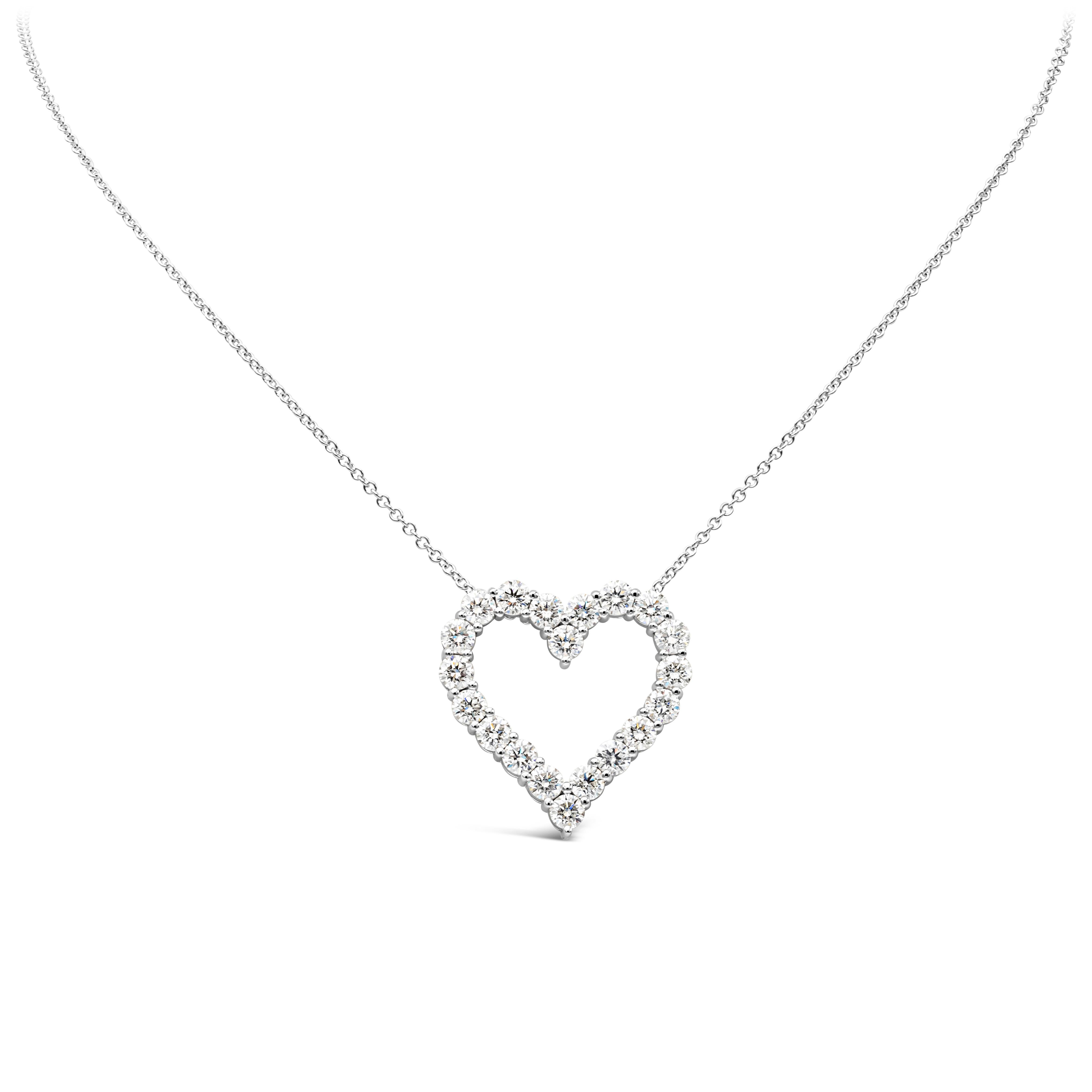 A simple and unique pendant necklace showcasing a row of round brilliant diamonds weighing 4.44 carats total, set in an open-work heart shape mounting made in 18k white gold and shared prong setting. Suspended on an adjustable white gold