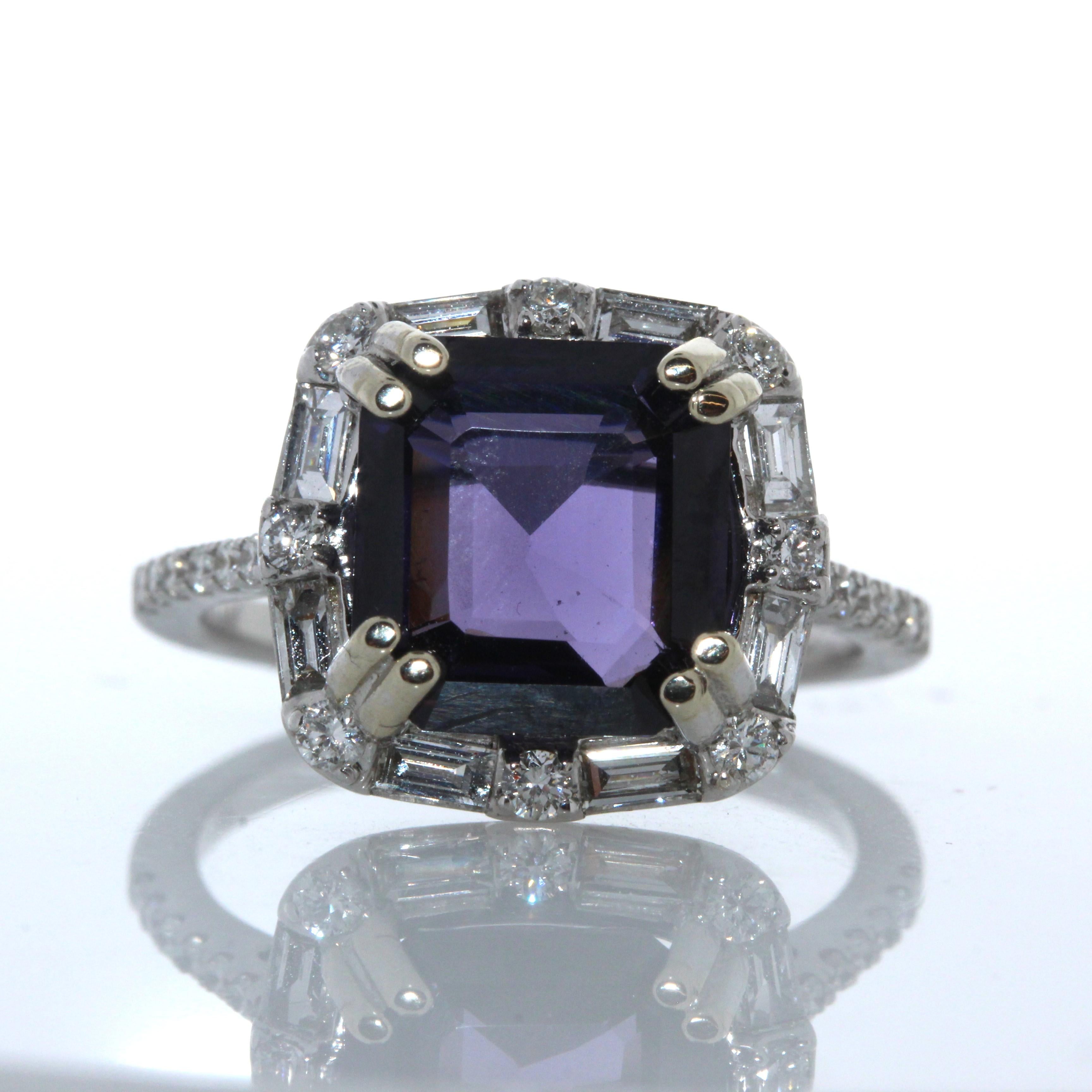 This is a cocktail ring that showcases a white gold, double prong set, 4.45 carat cushion cut purple spinel. The gem source is Sri Lanka; its transparency and luster are excellent. It has diamonds on the band and around the gemstone totaling 0.61