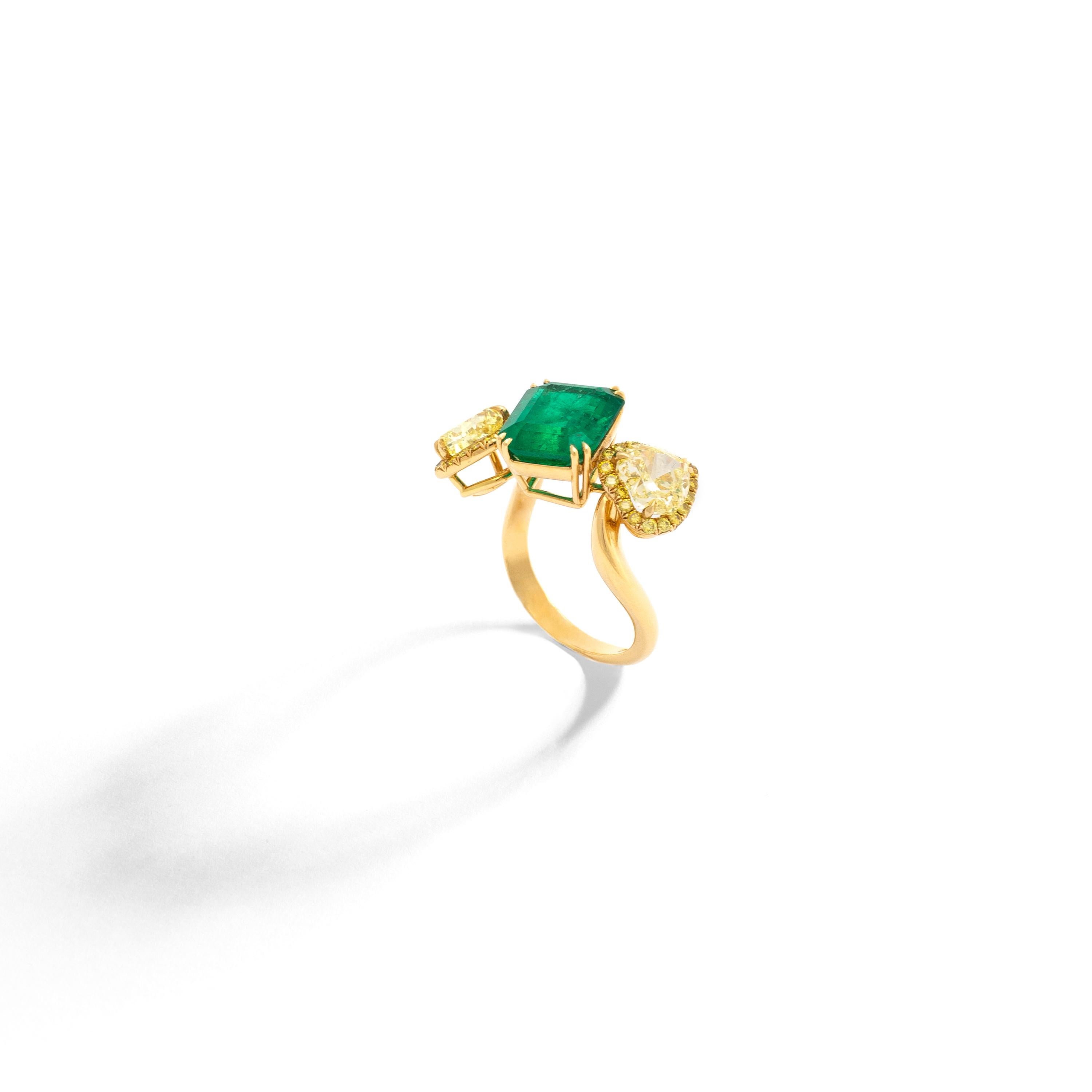 4.45 carats Emerald, heart shape Diamonds respectively 1.26 carats and 1.31 carats. 
The yellow gold 18k ring is set by 36 yellow diamonds 0.34 carat total.