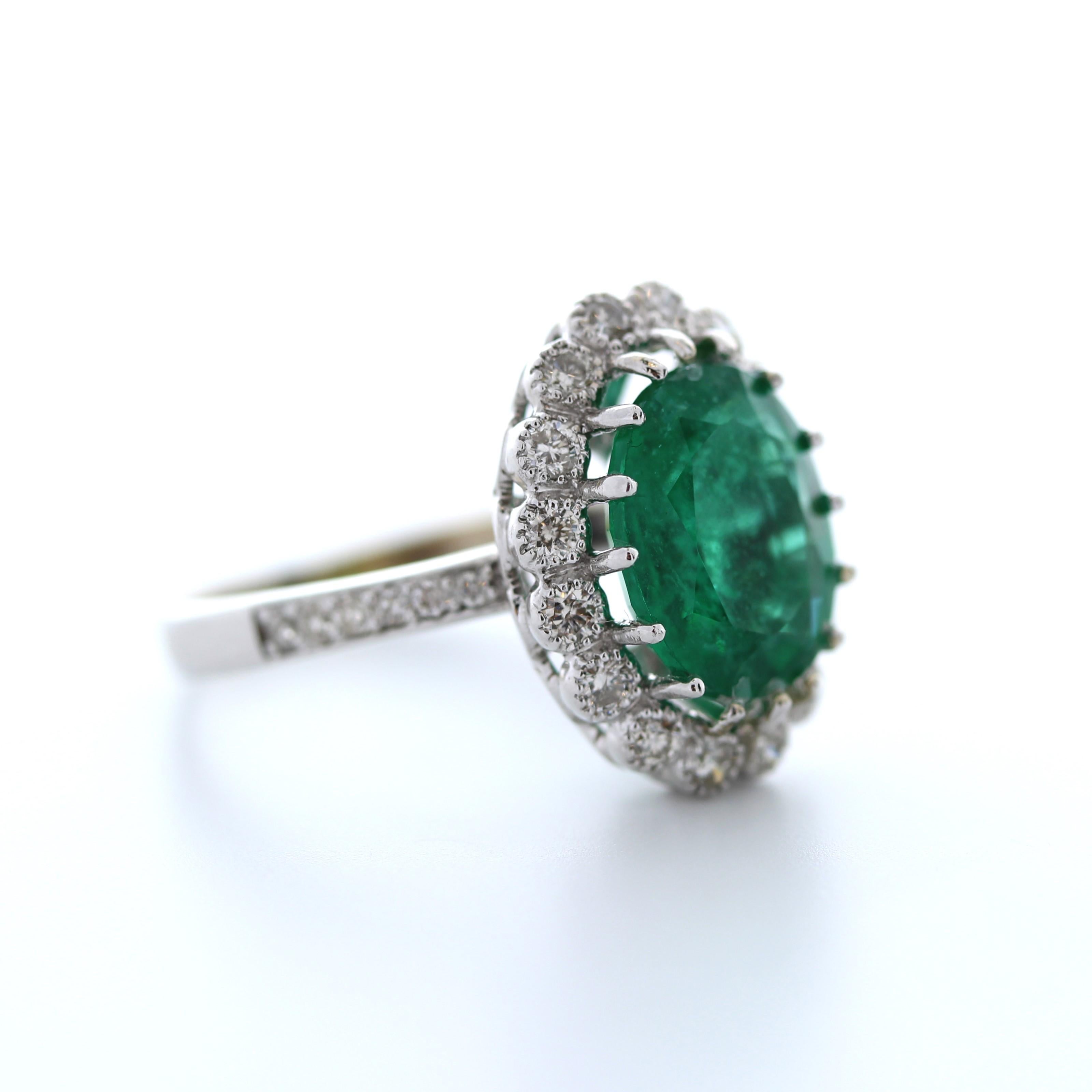 The 4.46 Carat Green Emerald Oval Shape & Diamond Ring in 14K White Gold is a stunning piece of jewelry that features a vibrant green emerald as its centerpiece. The emerald is an oval-cut shape, which gives it a classic and elegant look. The
