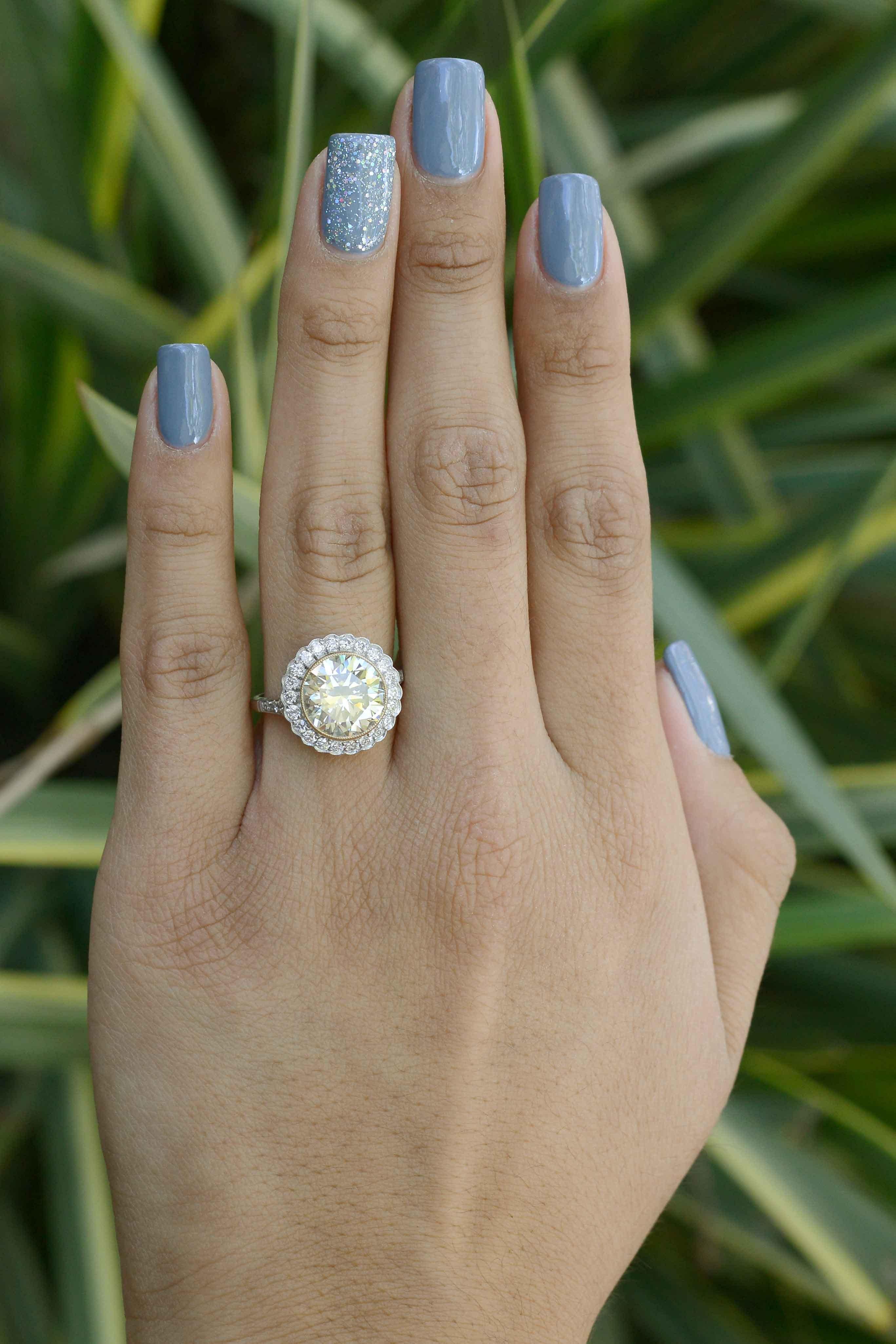 The Burlingame 4.46 carat round yellow diamond engagement ring is a huge, accented solitaire target style design. The natural canary yellow color contrasts nicely against a scalloped halo of sparkling white diamonds which adds to the allure of this