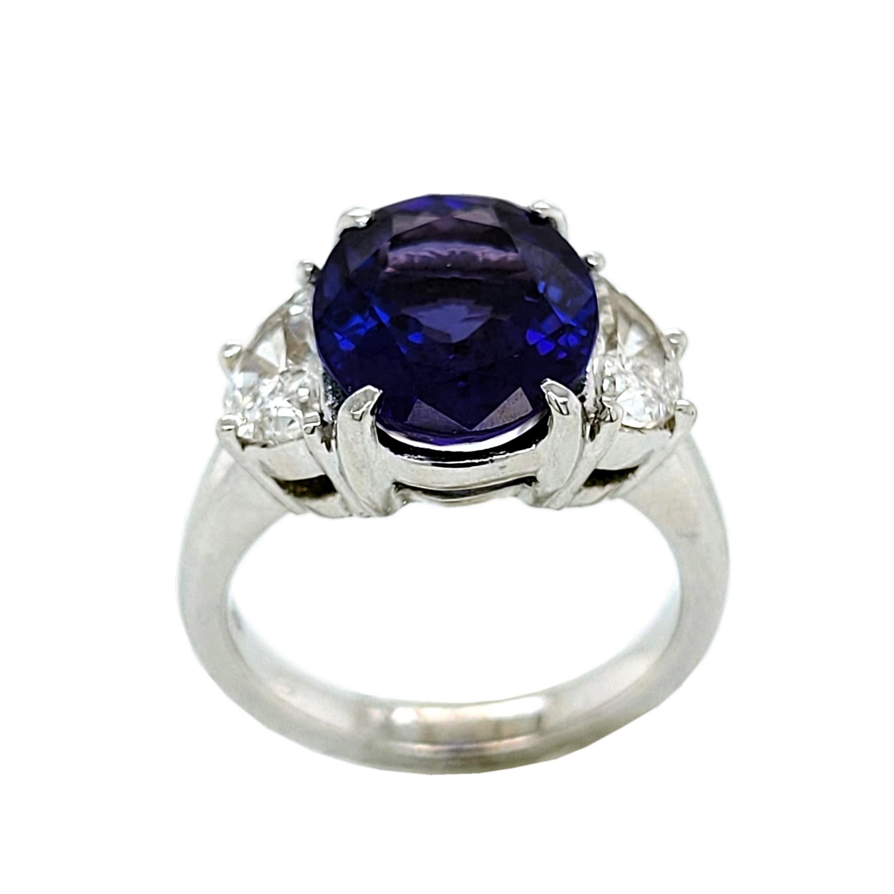 A beautiful color 4.47 Ct Oval shaped tanzanite set in the center of an 18K split 3 stone  with two Half Moon diamonds (TW; 0.93 Ct) engagement ring. 

Details:
Center Stone: 4.47 carat Oval Shape tanzanite
Side Stone Diamonds: 2 Half Moon diamonds