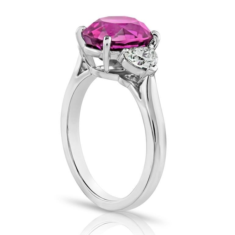 Zaffiro rosa ovale di 4,49 carati con due diamanti a cuore di 0,67 carati incastonati in un anello di platino fatto a mano