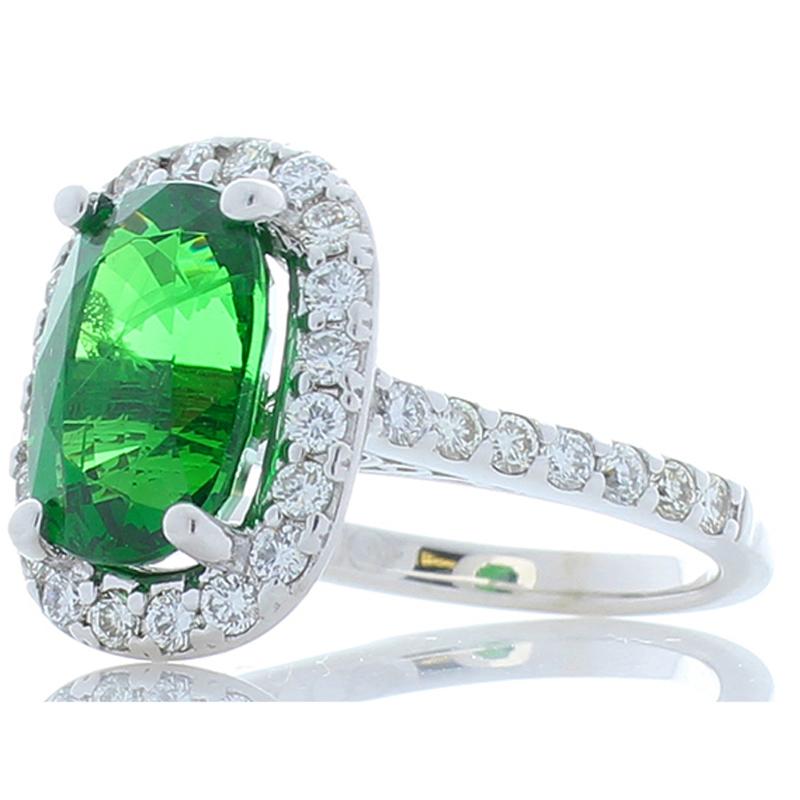 This fine tsavorite garnet and diamond ring has a ton of flair and chic style. An elegant oval 4.49 carat – 11.3 x 7.60 millimeter green tsavorite garnet, found in Tanzania, sits in the center. Its color is an intense and captivating green. Its