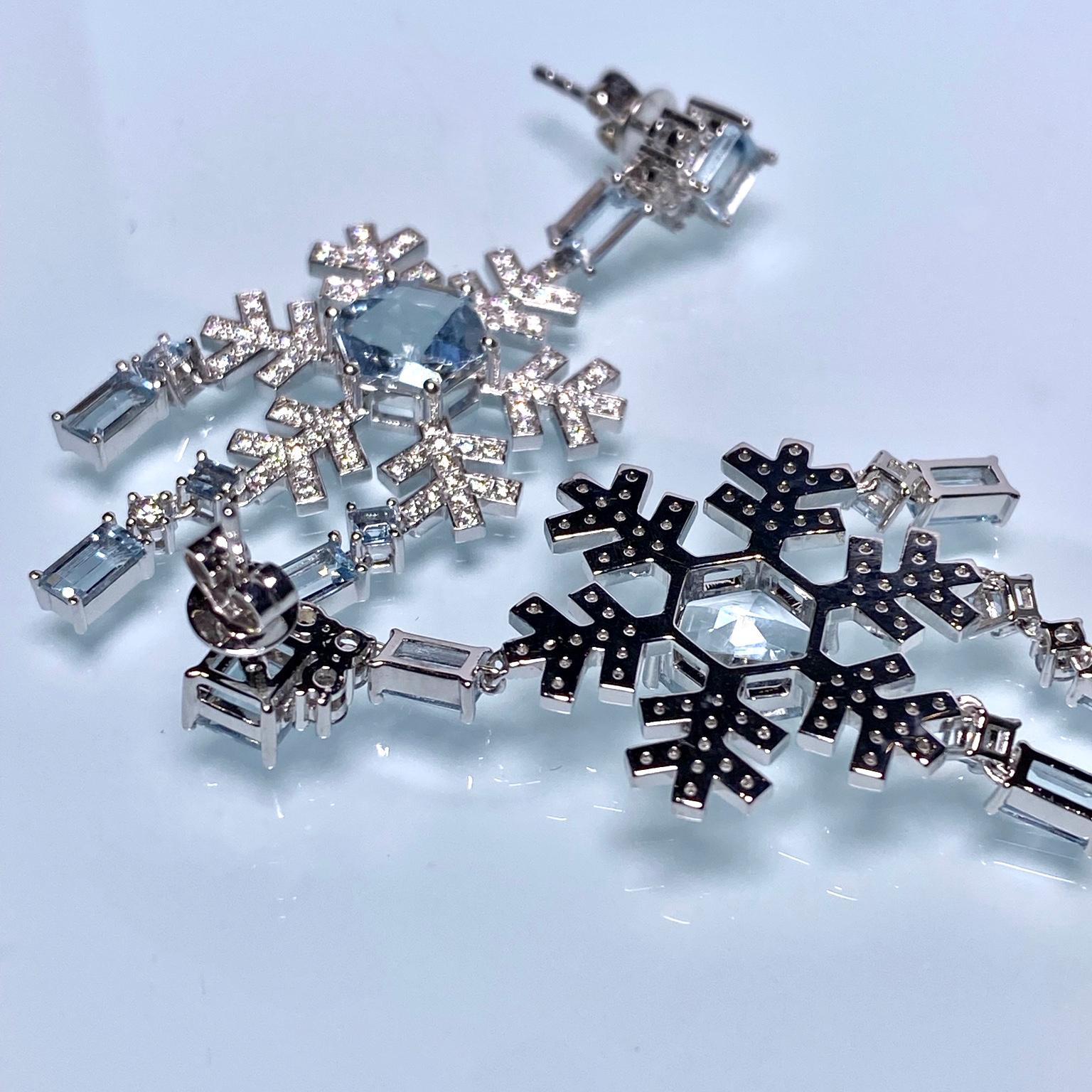This is a pair of snowflake design Chandelier Earring. The Snowflake is suspended below an Aquamarine and diamond motif. At the center of the snowflake, there is a hexagonal Aquamarine. It is a very contemporary design as will be more popular among