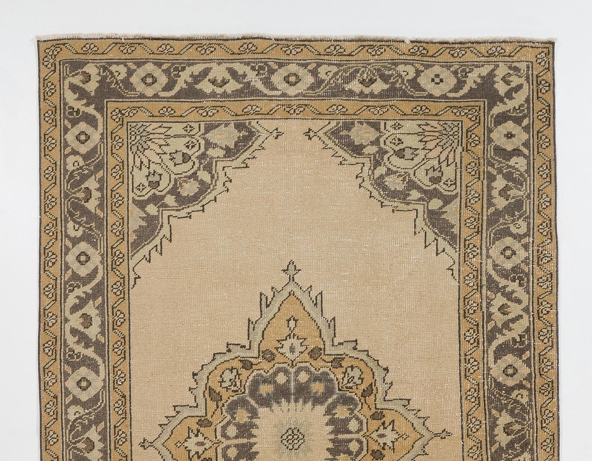 A vintage runner rug from Central Turkey. Finely hand-knotted with even medium wool pile on cotton foundation with a tri-medallion design in taupe gray, pale sage green and pale yellow against a stone beige plain field. The rug is in very good