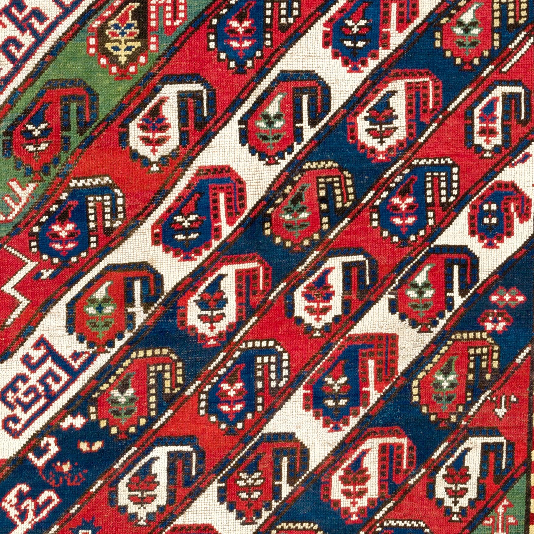 Ancien tapis caucasien Gendje Kazak avec des bandes diagonales décorées de Botehs et d'autres petits éléments de design attrayants et avec une bordure rouge représentant de nombreuses fleurs. Taille : 4.4 x 7.3 Ft
100% laine et teintures naturelles.