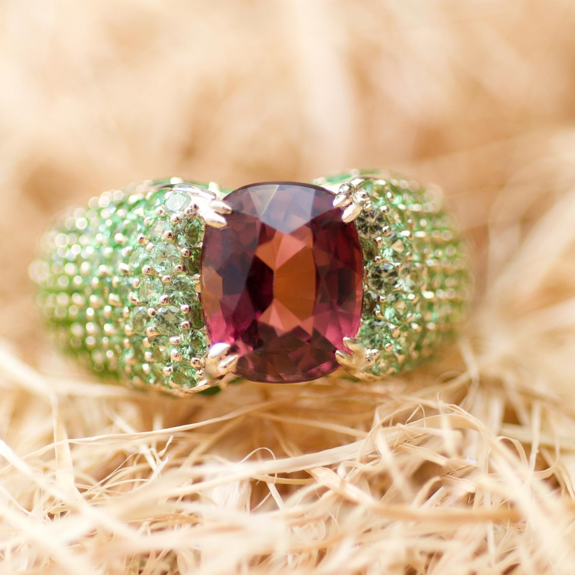 Sometimes the most unusual color combinations become the most beautiful. 
Peach-burgundy tourmaline, three shades of tsavorites and yellow gold.
You should not be afraid of vivid colors combinations, they always make the strongest impression.
It is