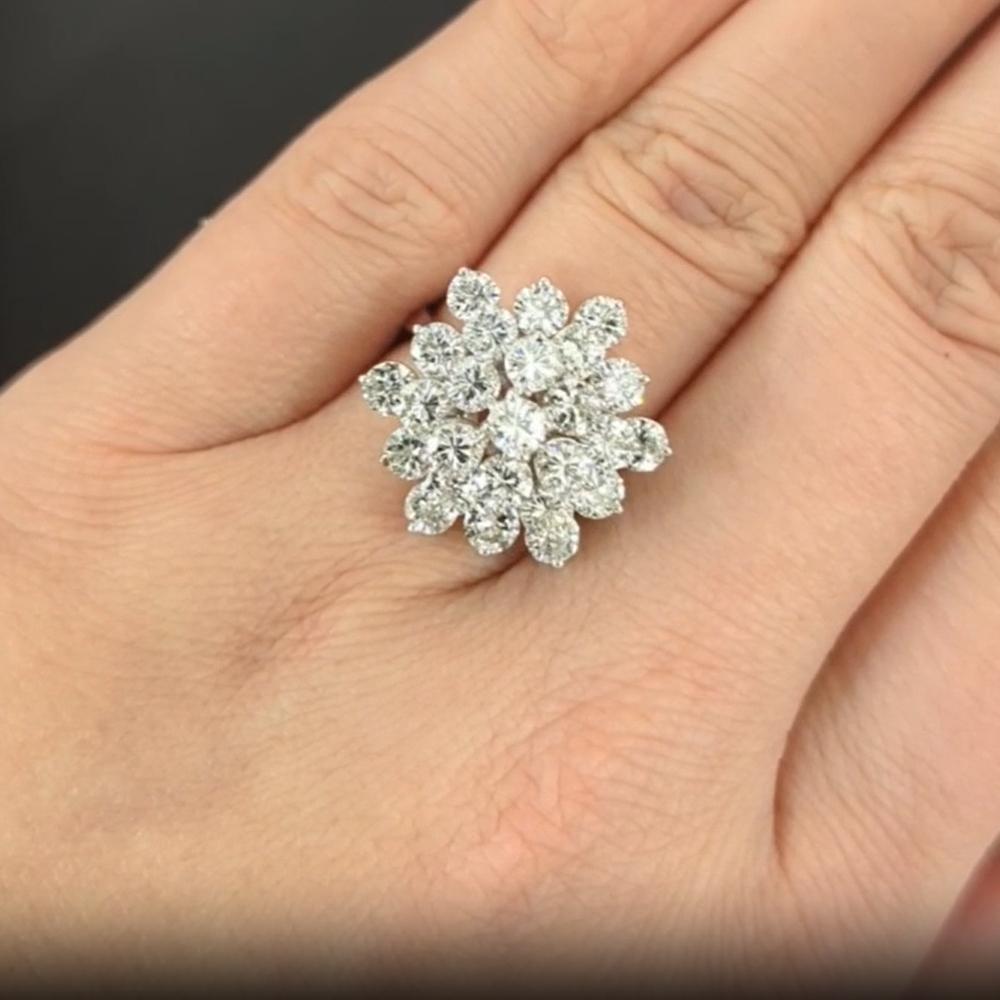 This vintage diamond cocktail ring makes a grand statement with its impressive 4.5 carats of high-quality diamonds, artfully arranged in a captivating cluster design. 

Originating from a bygone era, it boasts natural diamonds that are bright white