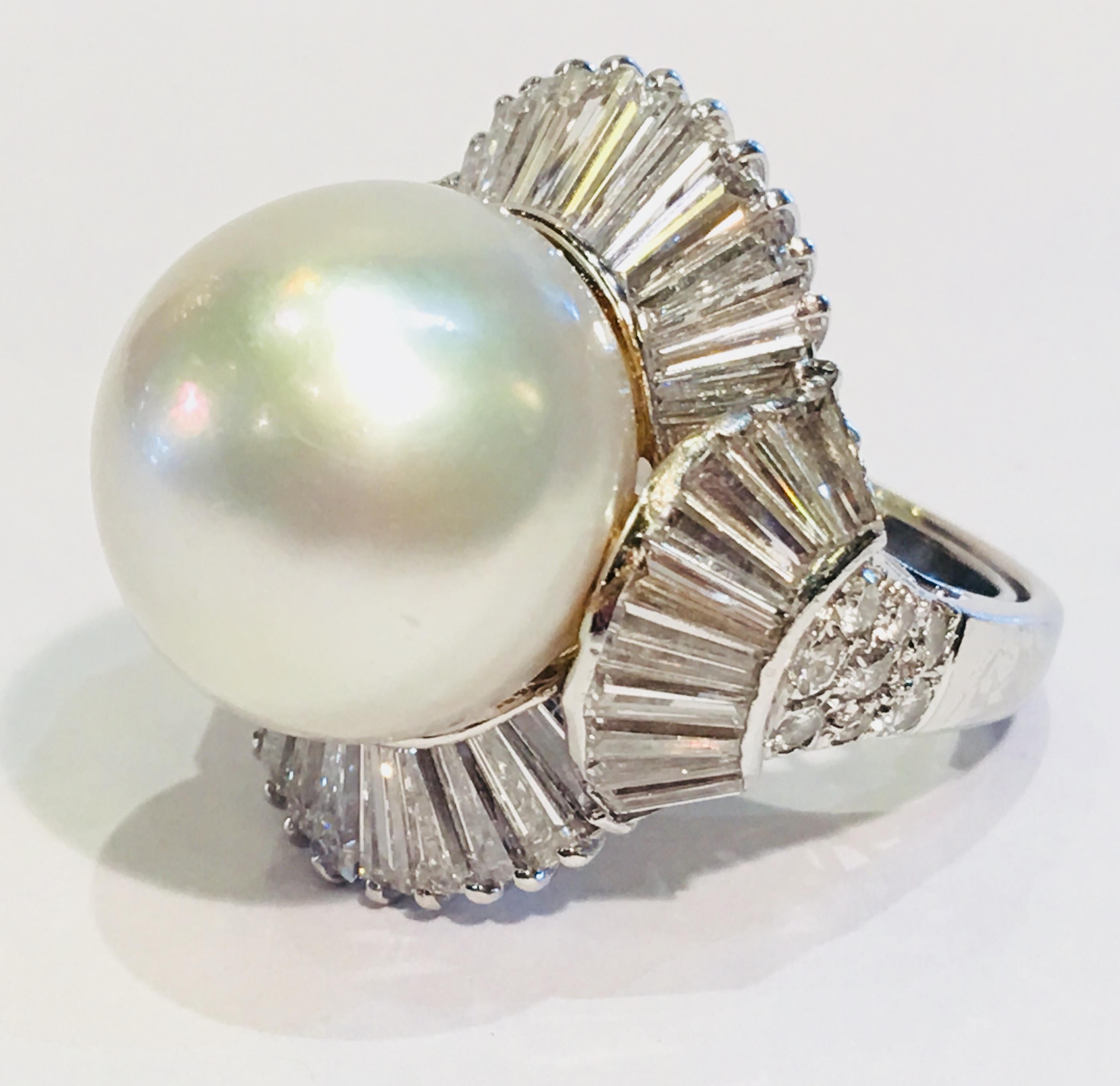 Magnificent very large single round 15.2 mm white South Sea pearl, with high luster and shine, is surrounded by 40 prong-set and invisibly set tapered diamond baguettes and accented with 16 round brilliant pave set diamonds in an 18 karat white gold