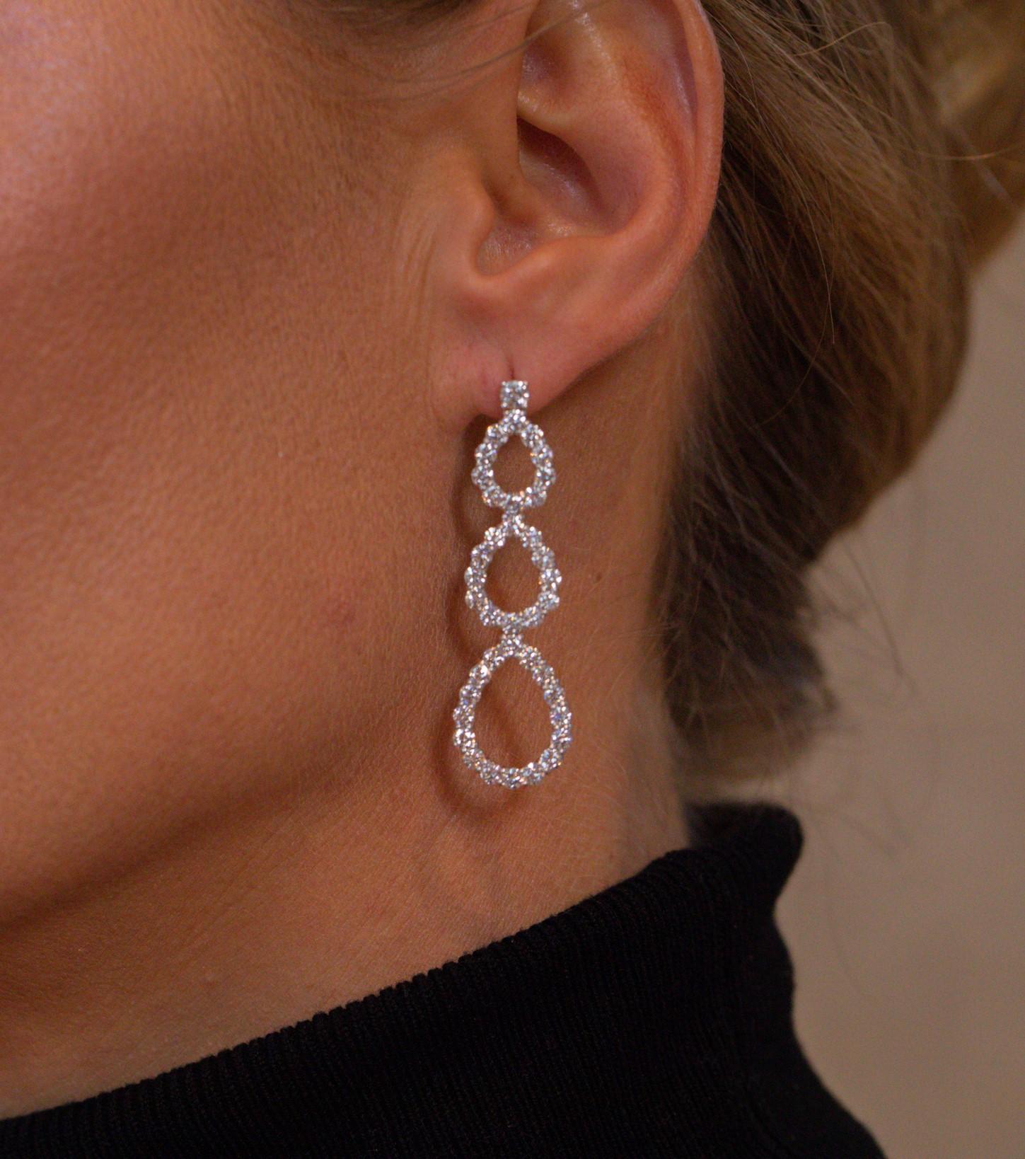 Graduated pear shapes made with 4.5 carats of white diamonds create an exquisite look.  Invisible connections between the pears allow for movement enhancing sparkle.  Created in platinum, each earring measures 2 inches.