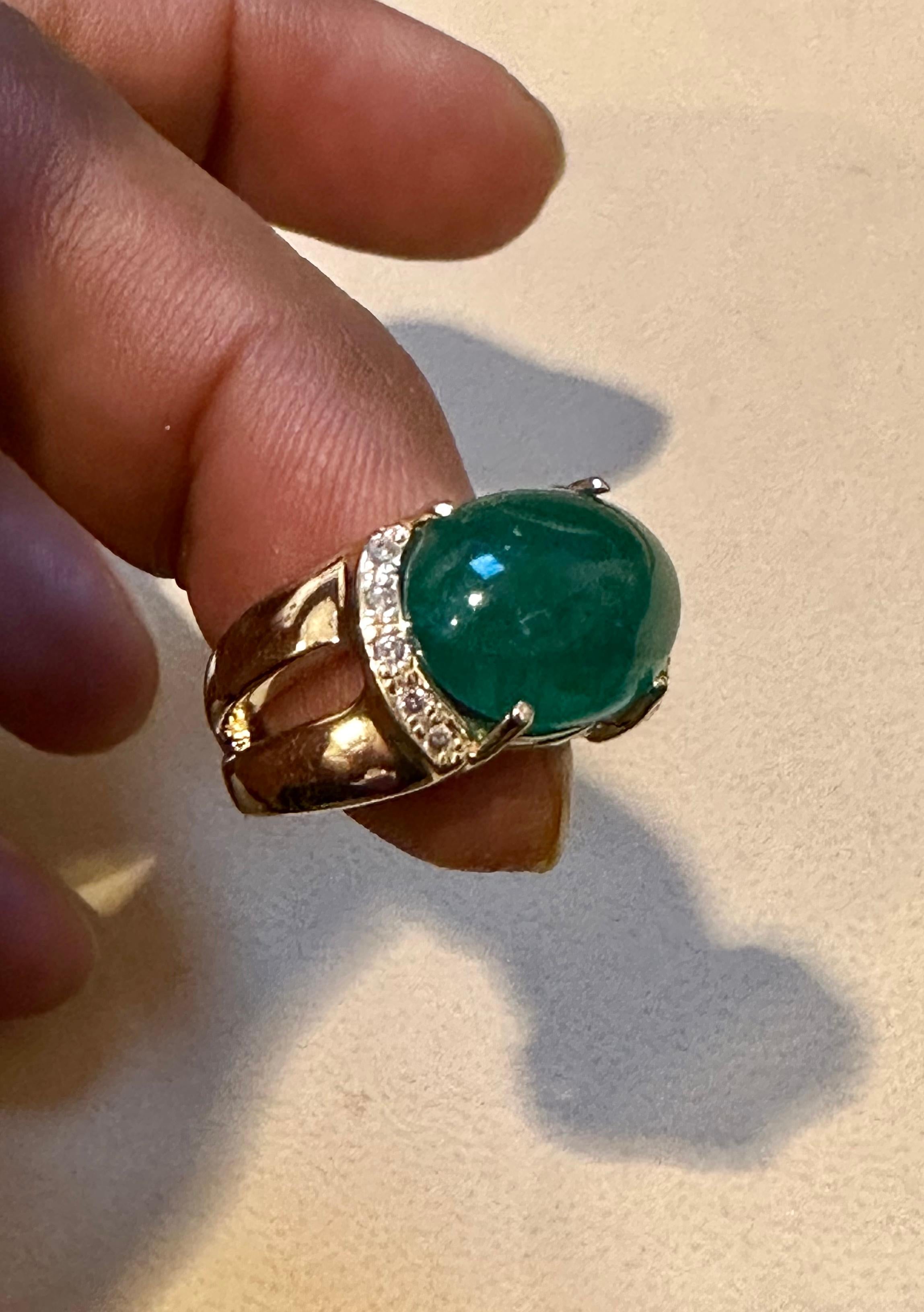 This classic cocktail ring is a stunning piece of jewelry that features a 4.5 carat natural emerald cabochon with two side rows of tiny diamonds. The estate piece has not undergone any color enhancement and is made of 14 karat yellow gold, stamped