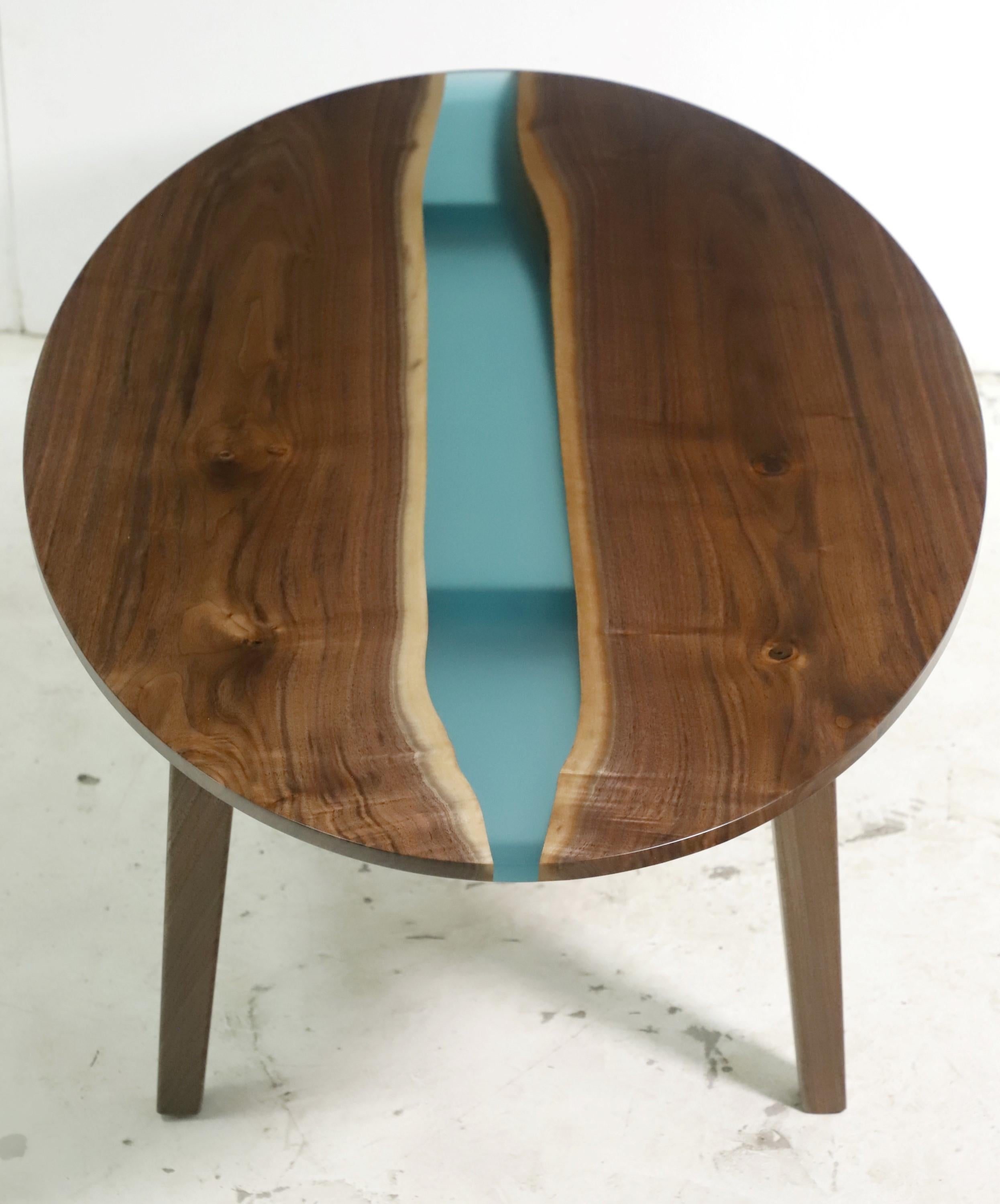 This table features a two slab solid walnut top with a blue green center resin detail pour paired with tapered legs. This table is ready to ship. Please note, this item is located in our Scranton, PA location.