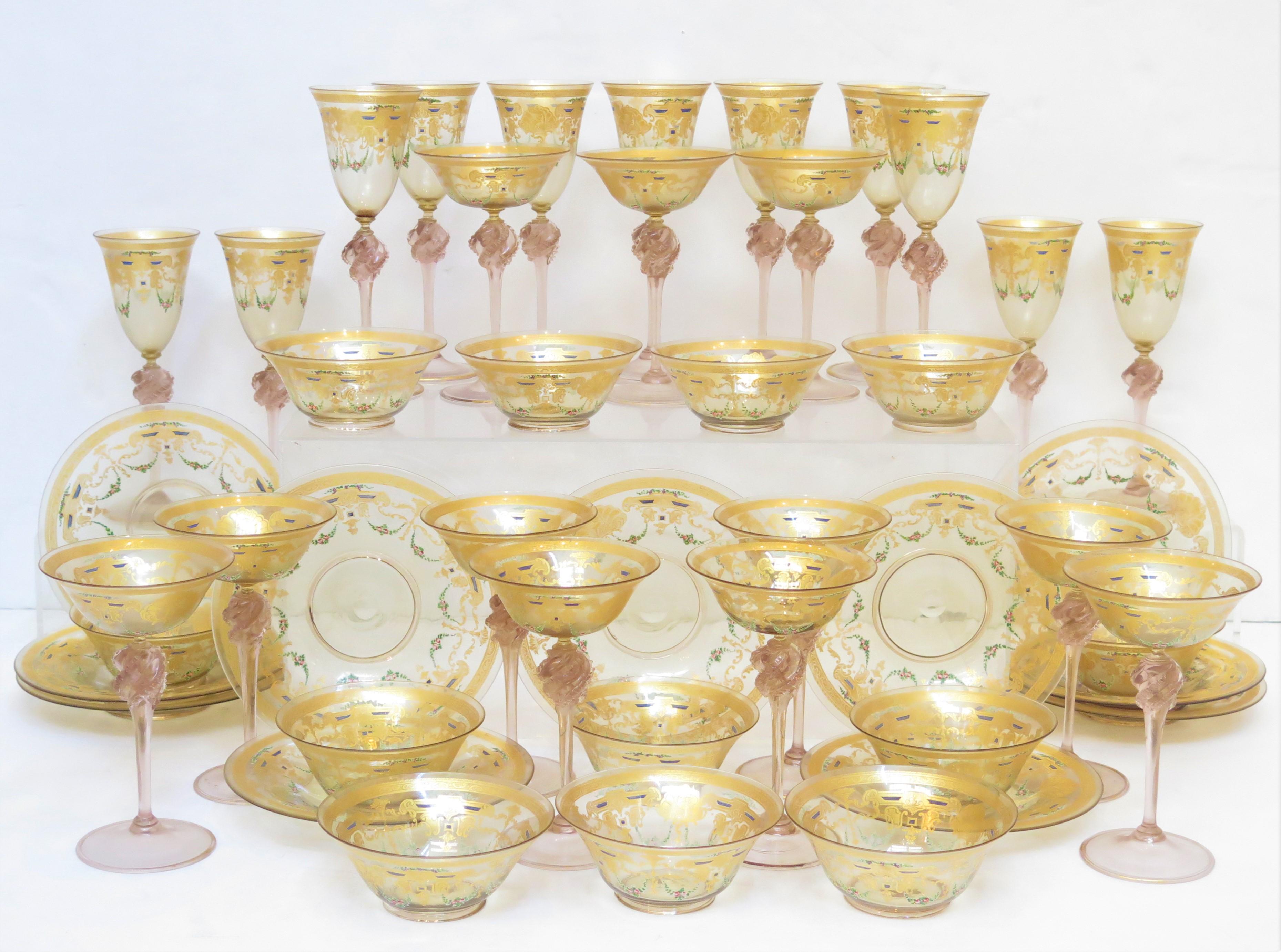 Ensemble de 45 pièces de verres à pied en verre vénitien de Murano, comprenant des coupes à champagne, des verres à vin, des petits bols et des assiettes avec un motif de vigne et de guirlande de fleurs peint à la main. Italie. 19ème siècle  