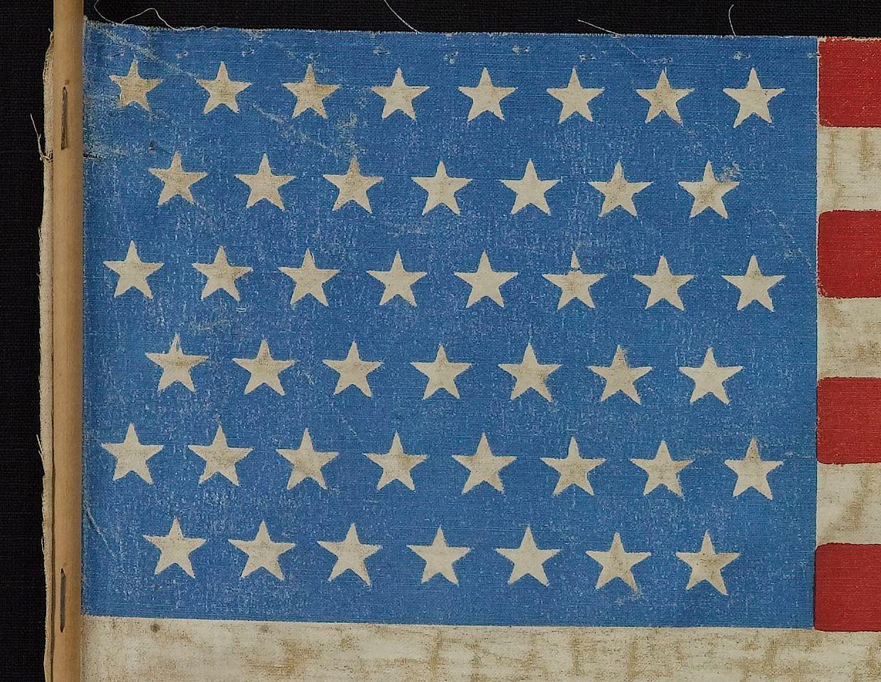 This 45-star United States flag celebrates the statehood of Utah. 45-star flags served as the official American flag from 1896-1908. This particular flag was flown as a parade flag, with part of its original stick still attached along the hoist. The
