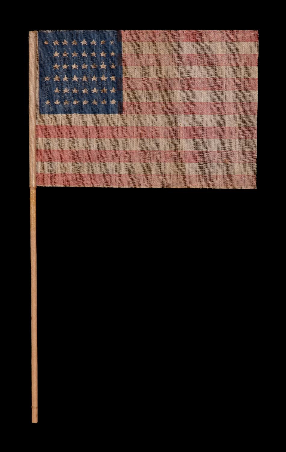 45 STAR ANTIQUE AMERICAN PARADE FLAG WITH ITS STARS ARRANGED IN A NOTCHED PATTERN, 1896-1908, UTAH STATEHOOD 

45 star American national flag, printed on coarse cotton, with its stars arranged in what has been termed a 