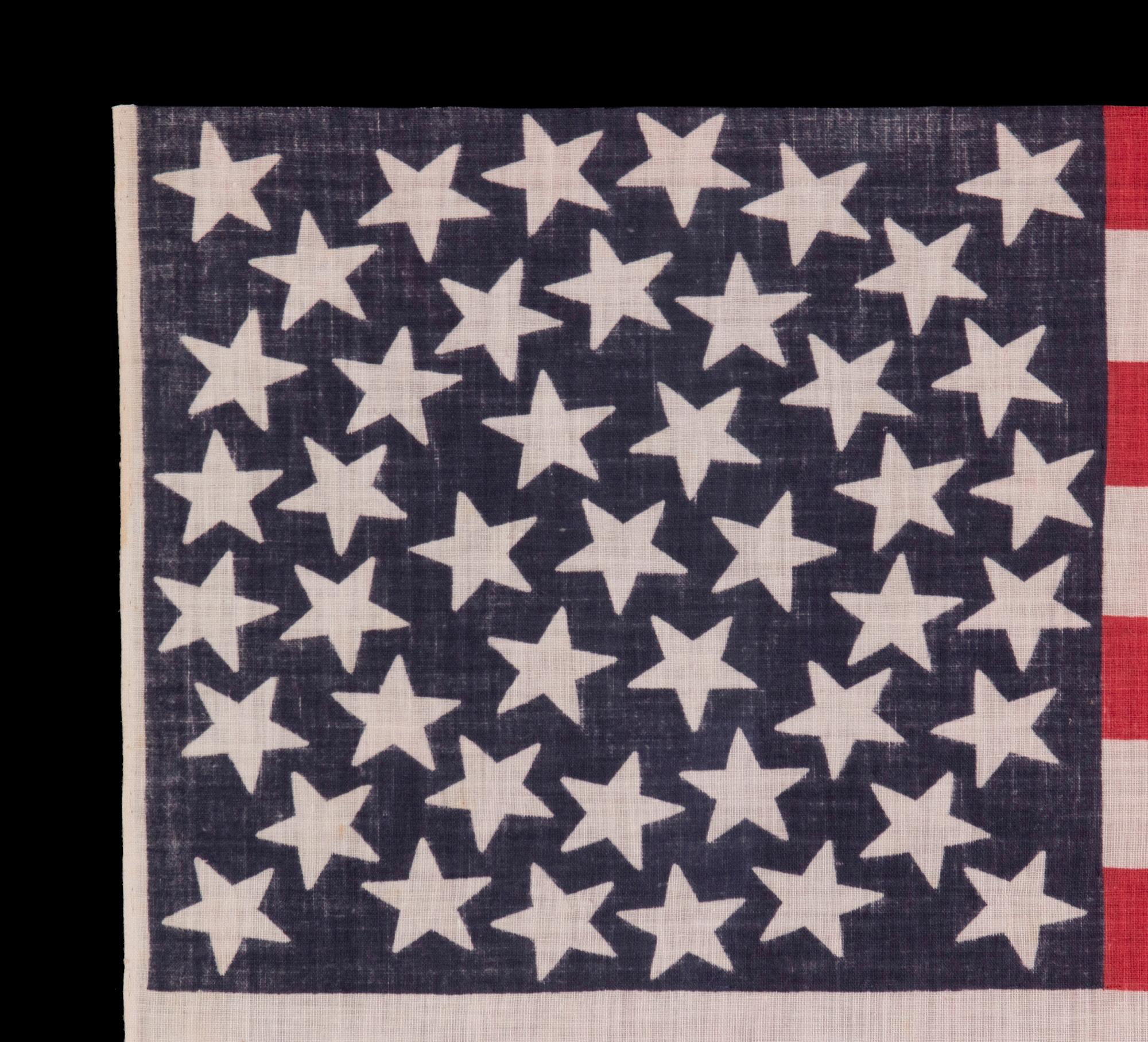 45 ESTRELLAS EN UNA ANTIGUA BANDERA DE DESFILE AMERICANA CON CONFIGURACIÓN DE MEDALLÓN, CARACTERÍSTICA POCO FRECUENTE EN ESTE PERIODO, 1896-1908, INDEPENDENCIA DEL ESTADO DE UTAH

Bandera de desfile estadounidense de 45 estrellas, impresa en
