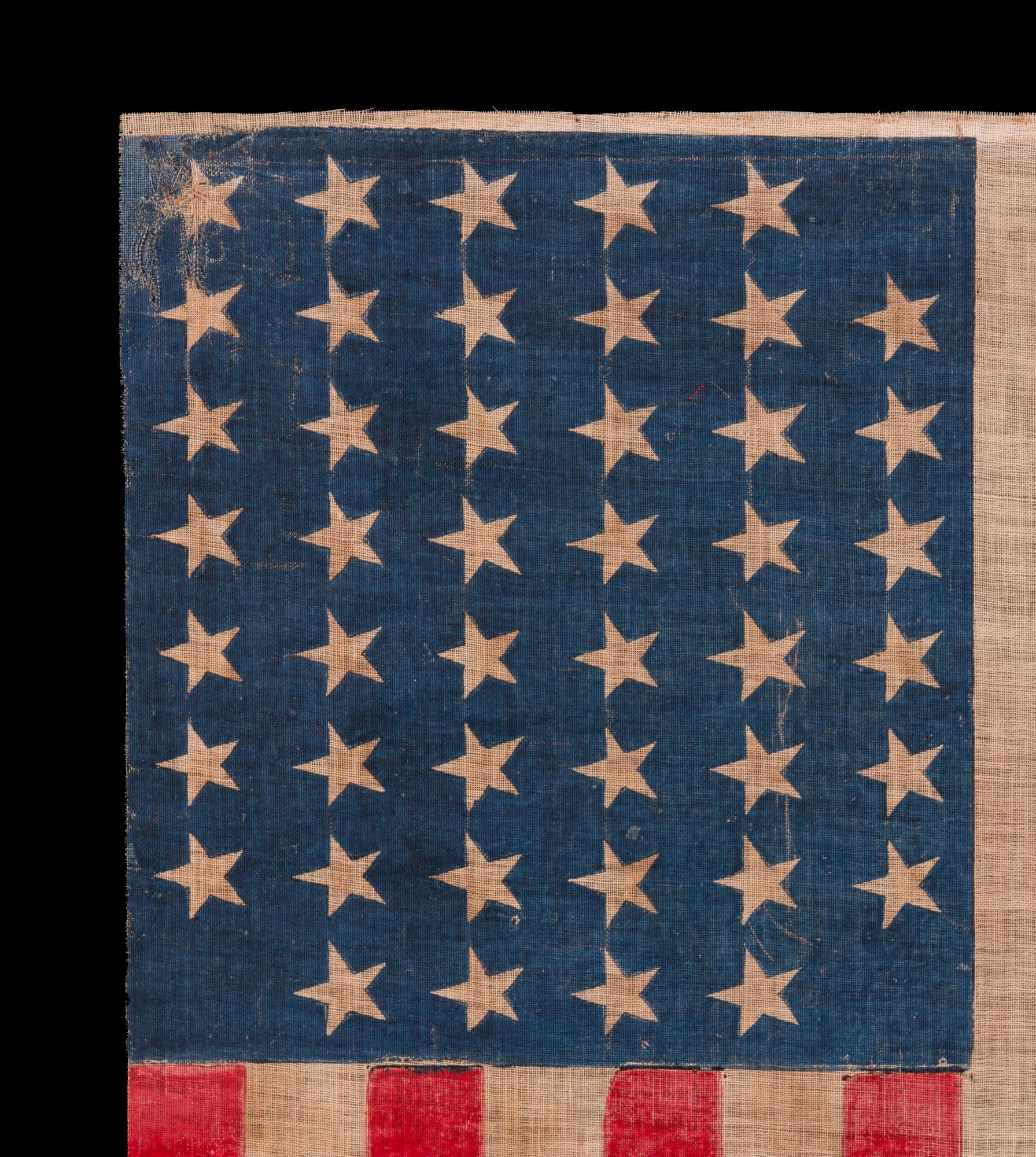 45 STAR ANTIQUE AMERICAN PARADE FLAG WITH ITS STARS ARRANGED IN A NOTCHED PATTERN, 1896-1908, UTAH STATEHOOD:

45 star American national flag, printed on coarse, glazed cotton. Evidence of the eagerness for new states is particular notable in the