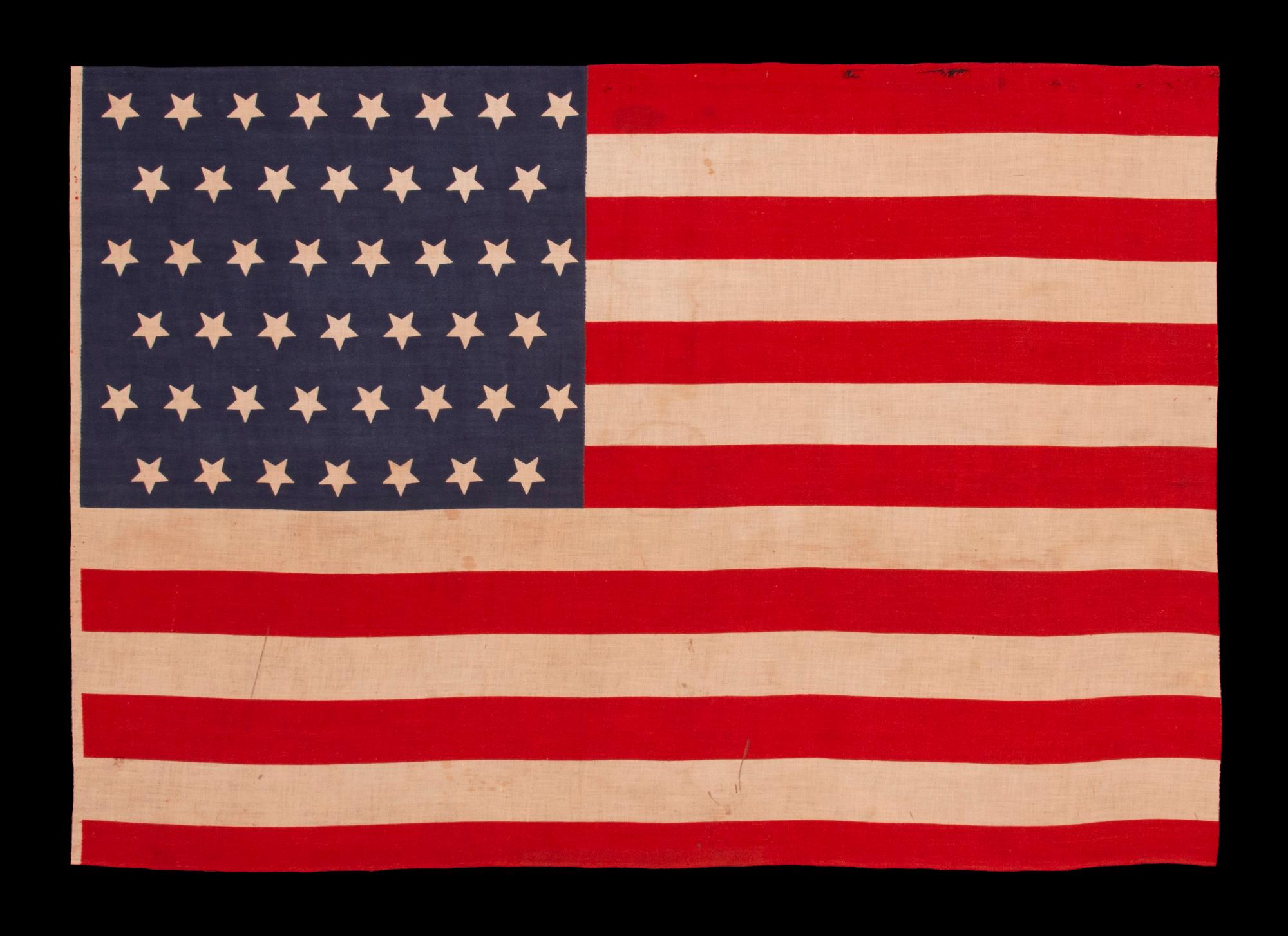 45 UPSIDE-DOWN STARS ON AN ANTIQUE AMERICAN FLAG MADE IN THE ERA OF THE SPANISH-AMERICAN WAR (1898), WHEN UTAH WAS THE MOST RECENT STATE TO JOIN THE UNION, circa 1896-1908

45 star American national parade flag, printed on plain weave cotton. Note