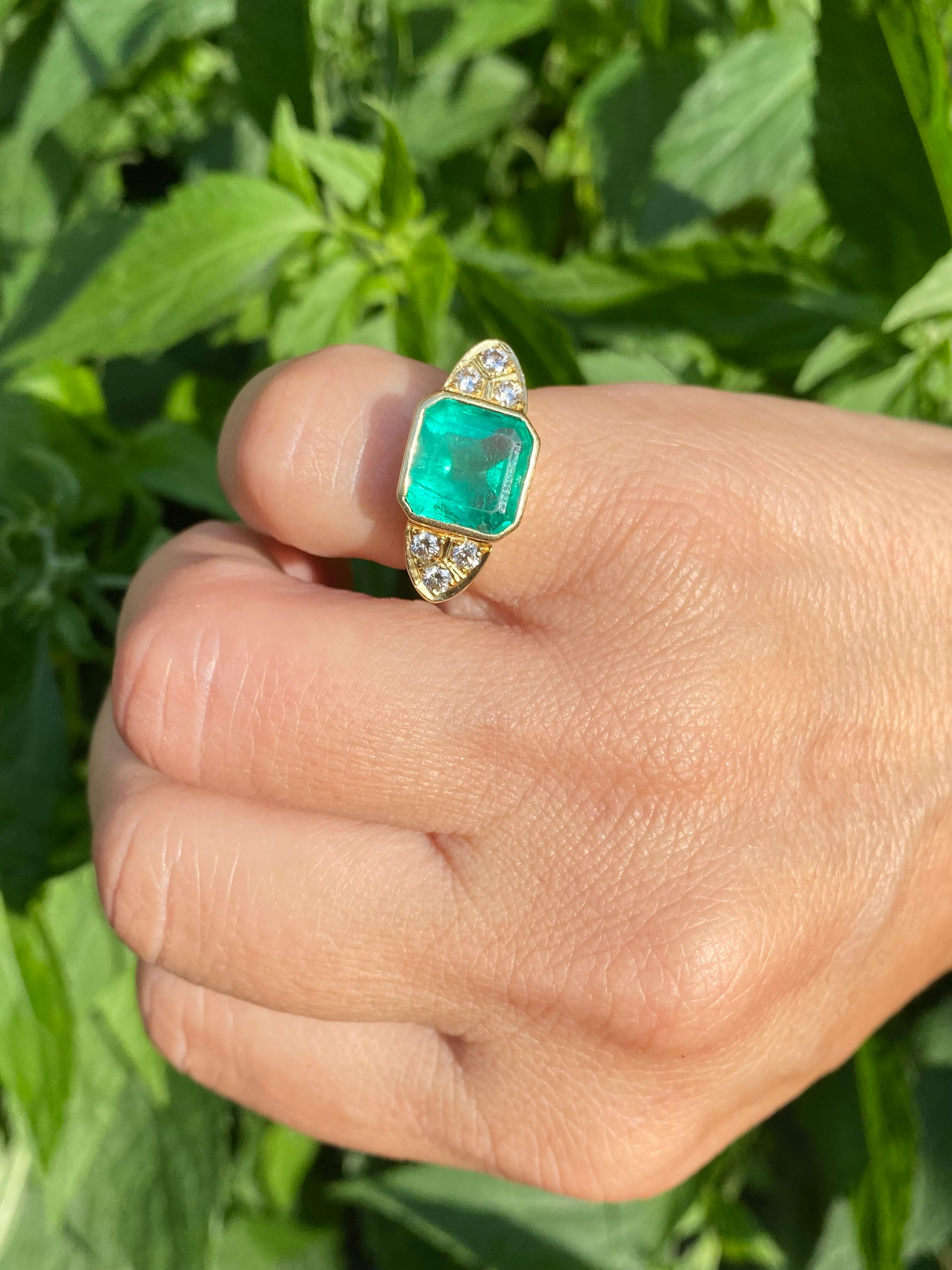 Unisex Colombian Emerald ring with 6 natural diamond side stones. This ring has structural and aesthetic versatility for both everyday wear and special occasions. The Emerald is mounted in a bezel setting, thereby significantly decreasing the