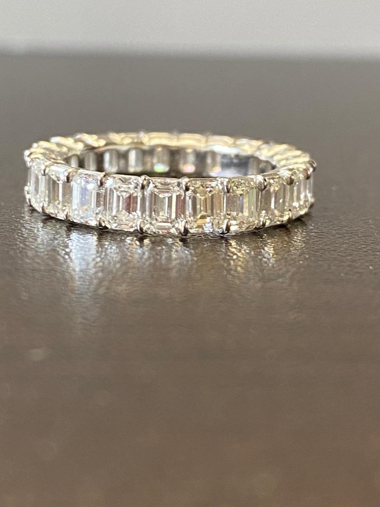 Emerald Cut Eternity diamond ring set in platinum. The ring is set with 23 stones each weighing 0.20 carats. The total diamond weight is 4.66 carats. The color of the stones are F, the clarity is VS1-VS2. The ring is a size 6.5.