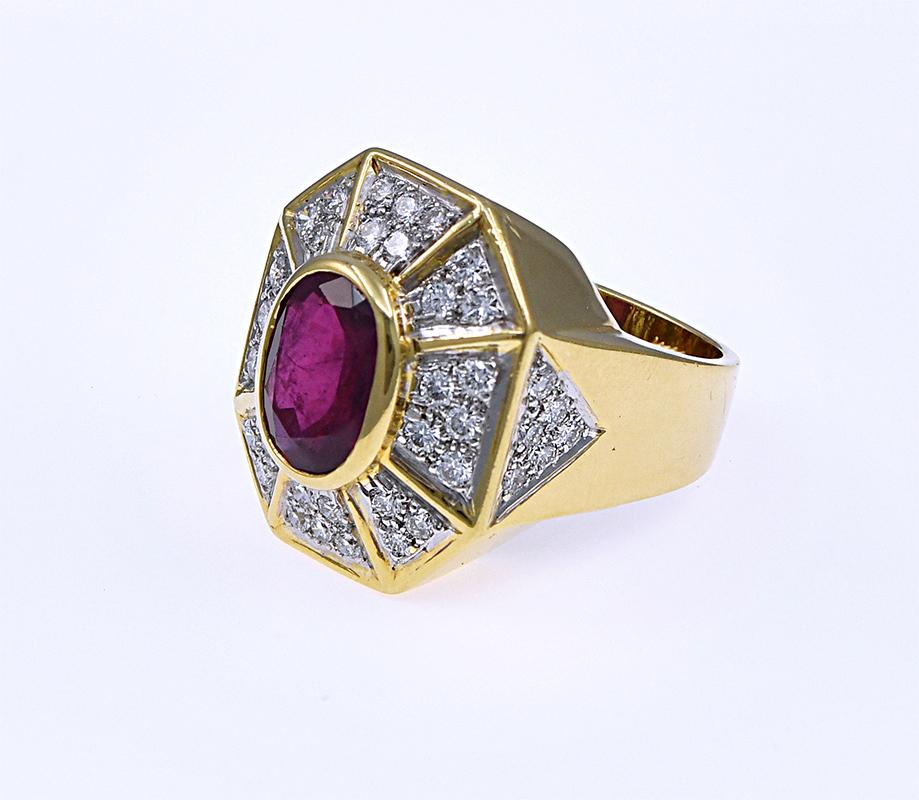 A Large Ornate Elongated Octagon shaped Ruby and diamond ring crafted in a beautiful 18 karat yellow gold. This beautiful ring features an oval shaped Ruby that weighs 4.50 carats and is surrounded by  32 stones of round diamonds weighing