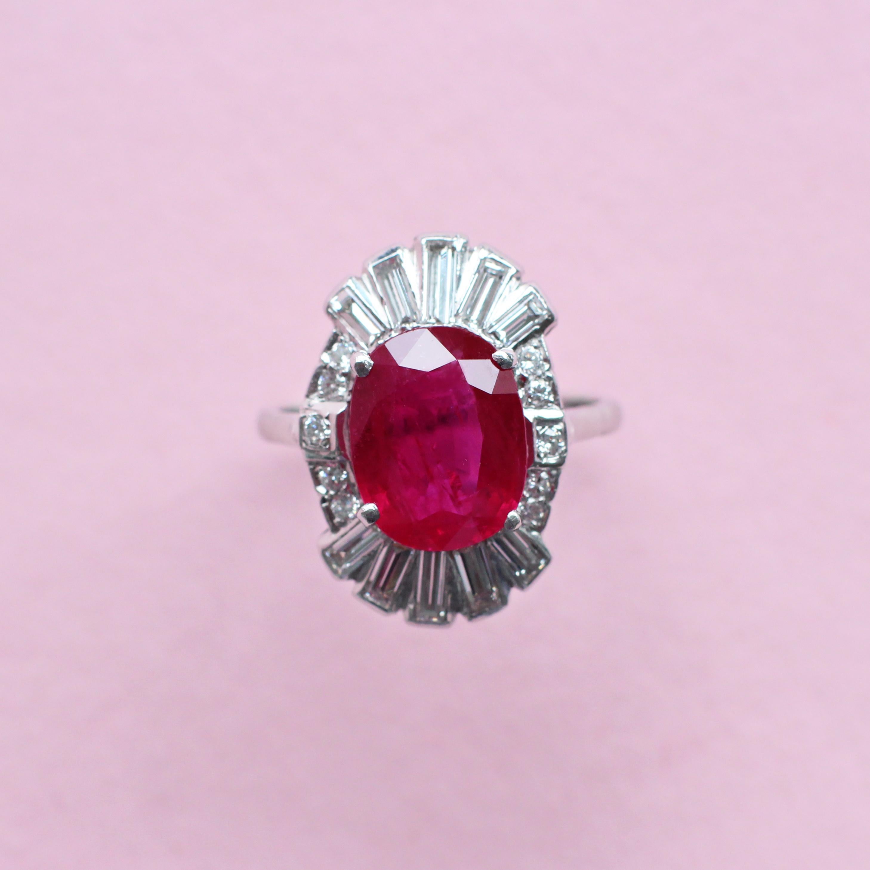 A truly exceptional piece from our London atelier, this vintage-style ring demands attention. At its centre is a large, bright red ruby in a timeless oval cut, embraced by a baguette and round brilliant diamond surround. Sparkling yet sophisticated,