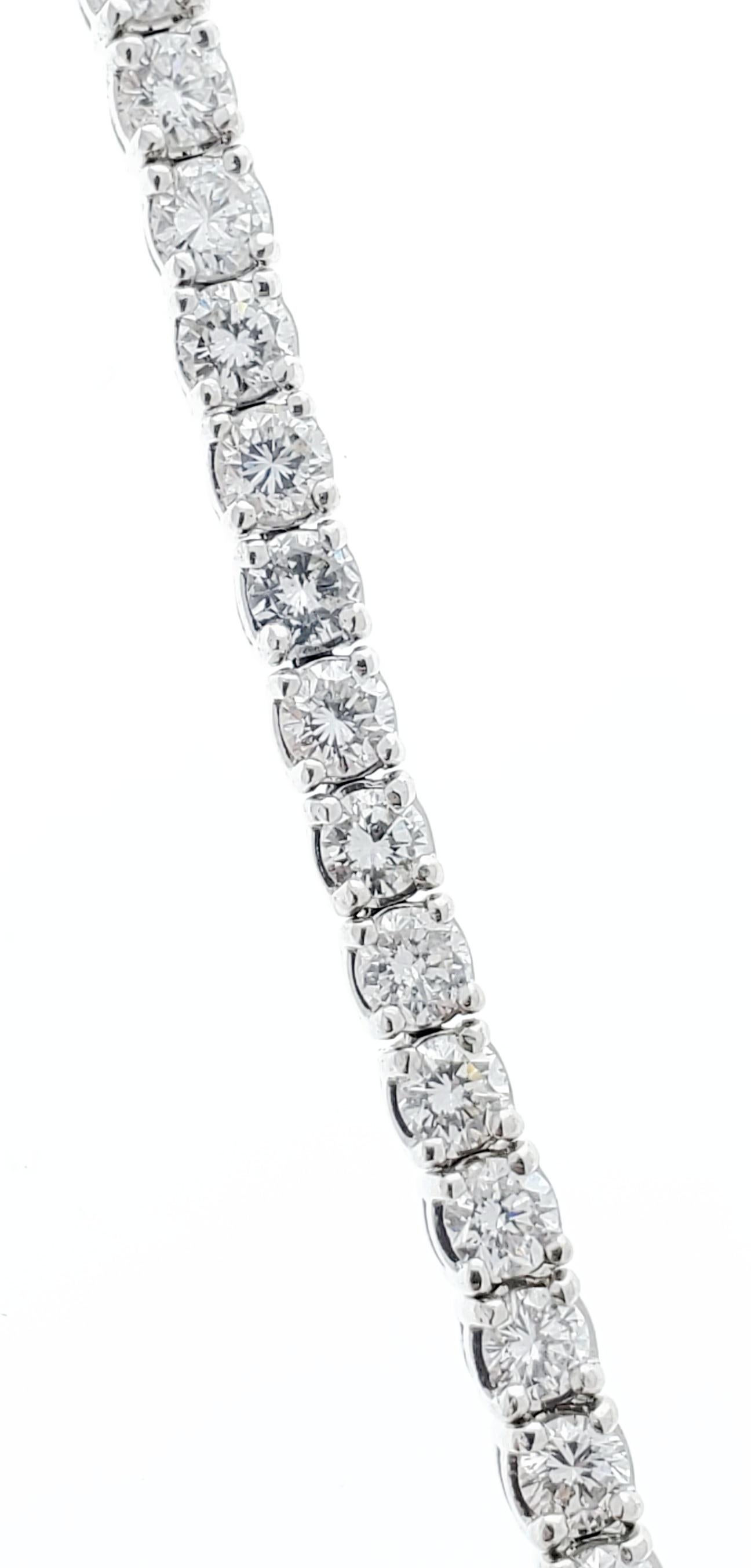 Designed in 14 karat white gold, this gorgeous classic tennis bracelet features a total of 4.50 carats of 59 sparkling round brilliant cut diamonds that are basket prong set around it, eternity style. This sophisticated tennis bracelet is finished