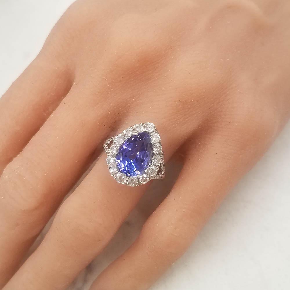 What a masterpiece! When eyes are fixed upon this ravishing beauty, all will likely concur that this ring is modern and elegant. At the heart of this ring sits a vivid violet-blue, with flashes of red, colored 4.50 carat, measuring 12.70 x 9.01