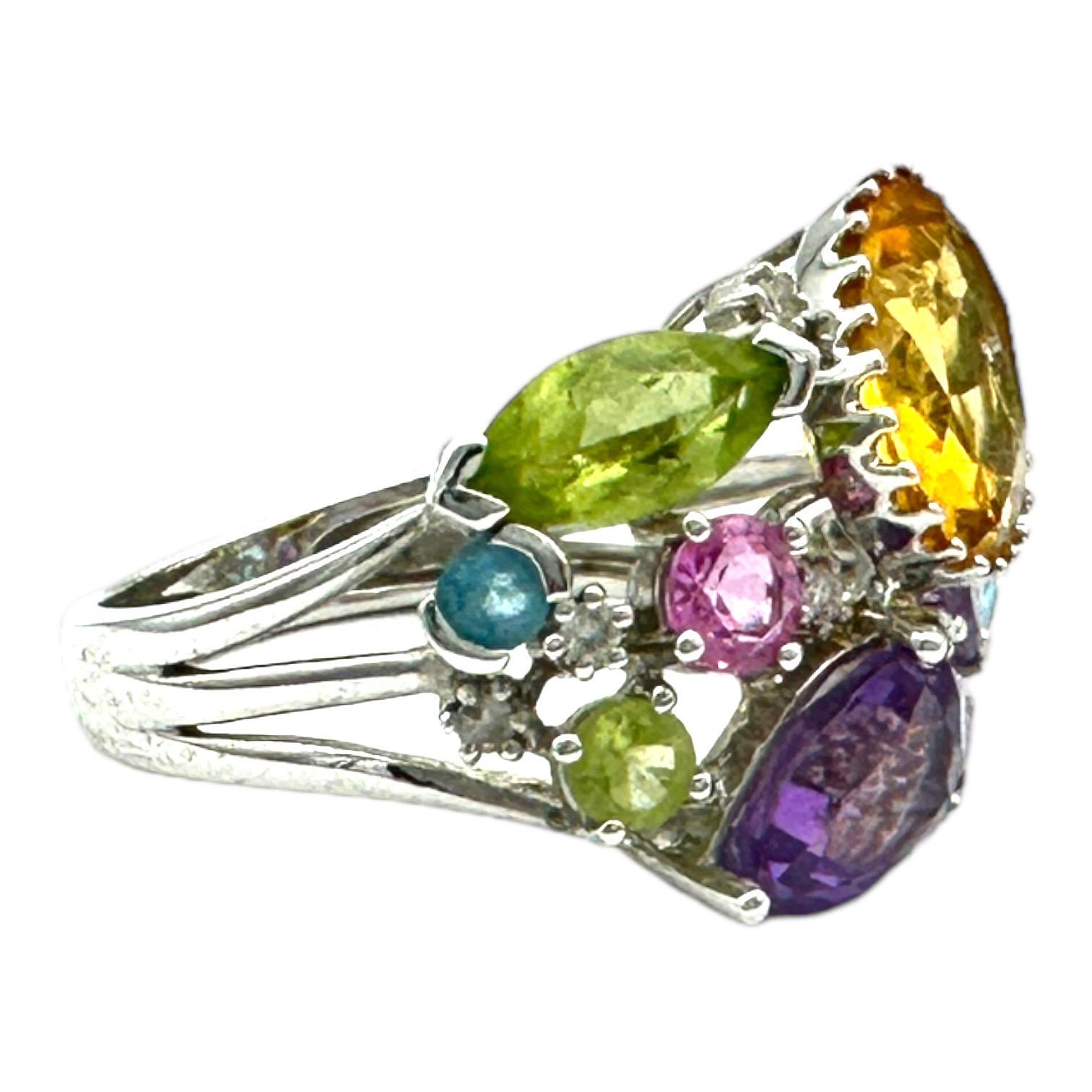 The 4.50 CTW Colored Gemstone Confetti Ring is the perfect accessory to add color to any look. This stunning ring is crafted with 14-karat white gold for maximum shine and durability and features a 15 mm wide band for a dazzling effect. With a