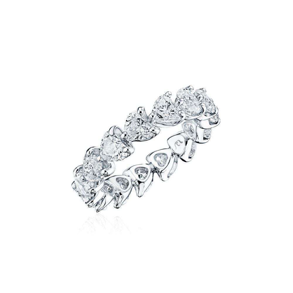 Crafted in 18KT gold, this eternity band is made with 15 heart shape diamonds which encircle the finger, and has a combining total weight of approximately 4.50 carats. The diamonds are set east to west in a shared prong setting. Worn beautifully on