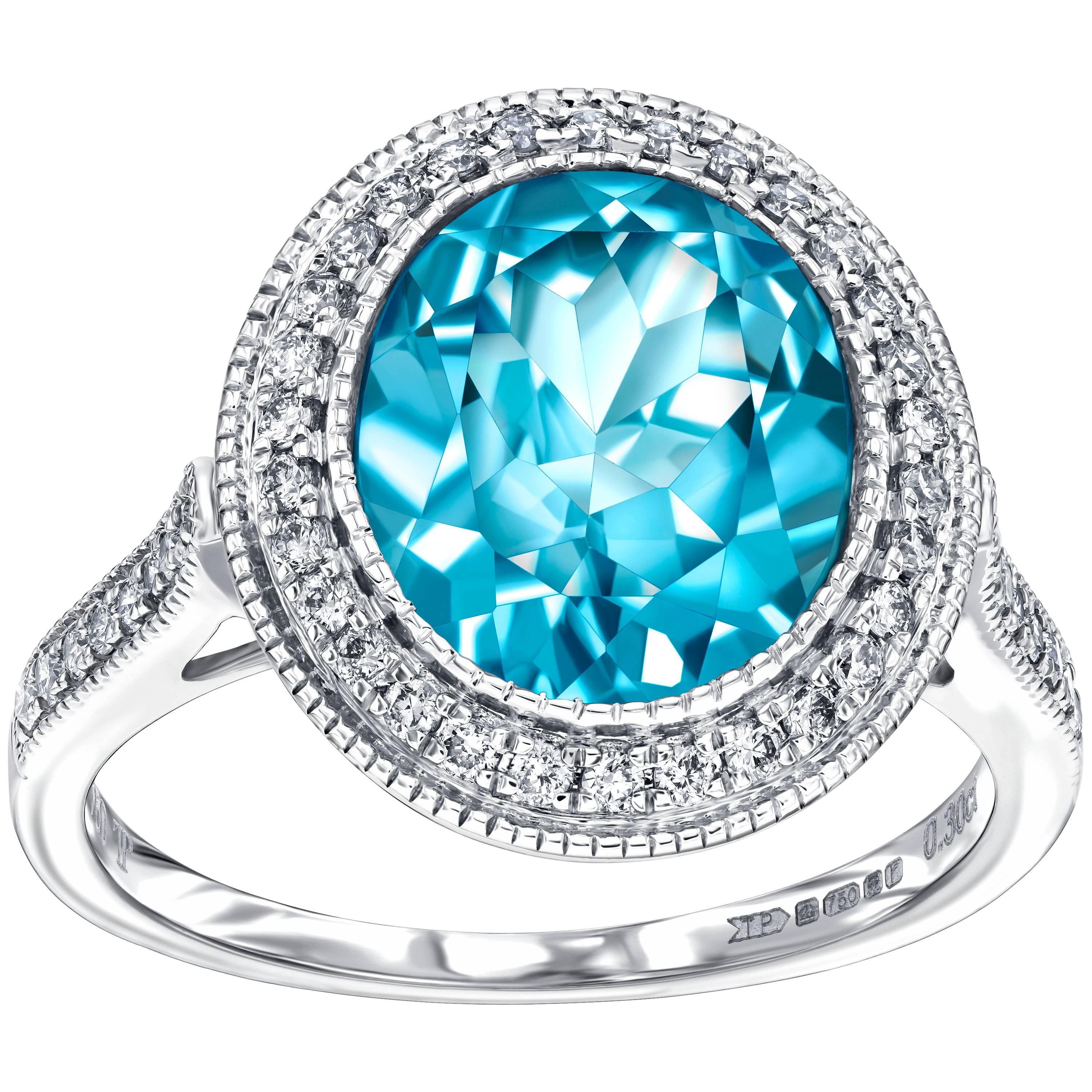 This Contemporary 4.50 Carat Blue Topaz Oval Cut Engagement Ring featuring 0.33ct Round Brilliant H-SI Diamonds which are accentuated on the shoulders. This ring has a total gem weight of 4.83 carats. With a quality grading of H-SI the weight of the