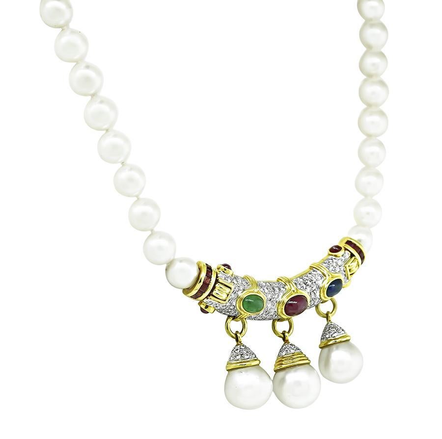 This is a gorgeous 18k yellow gold pearl necklace. The necklace is set with lovely cabochon sapphire, emerald and ruby that weigh approximately 4.50ct. The colored stones are accentuated by sparkling round cut diamonds that weigh approximately