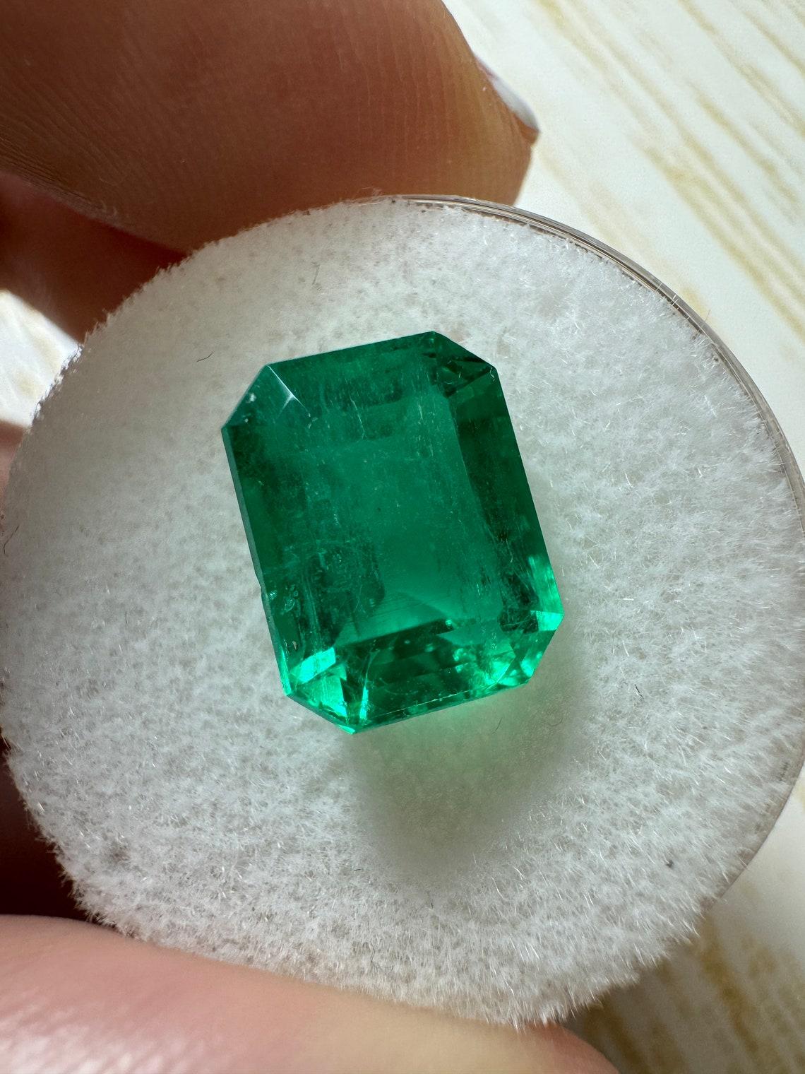 Stone: Emerald
Weight: 4.53-carats
Shape: Emerald Cut
Clarity: Transparent
Luster: Very Good
Color: Vivid Muzo Green
Measurements: 10.74mm x 8.19mm x 6.63mm
Geographic Origin: Colombia
Treatment: Natural, Oiling

Comments: Due to their growth