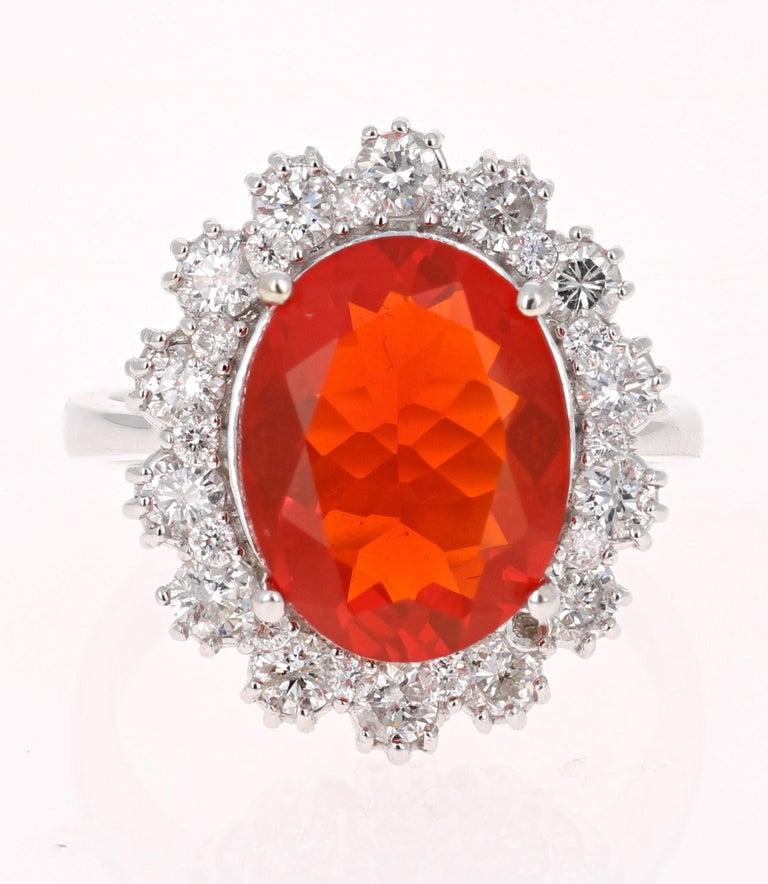 Beautiful Orange Fire Opal and Diamond Ring. This ring has a 3.39 carat Oval Cut Fire Opal in the center of the ring and is surrounded by a halo of 18 Round Cut Diamonds that weigh a total of 1.14 carats.  The total carat weight of the ring is 4.53