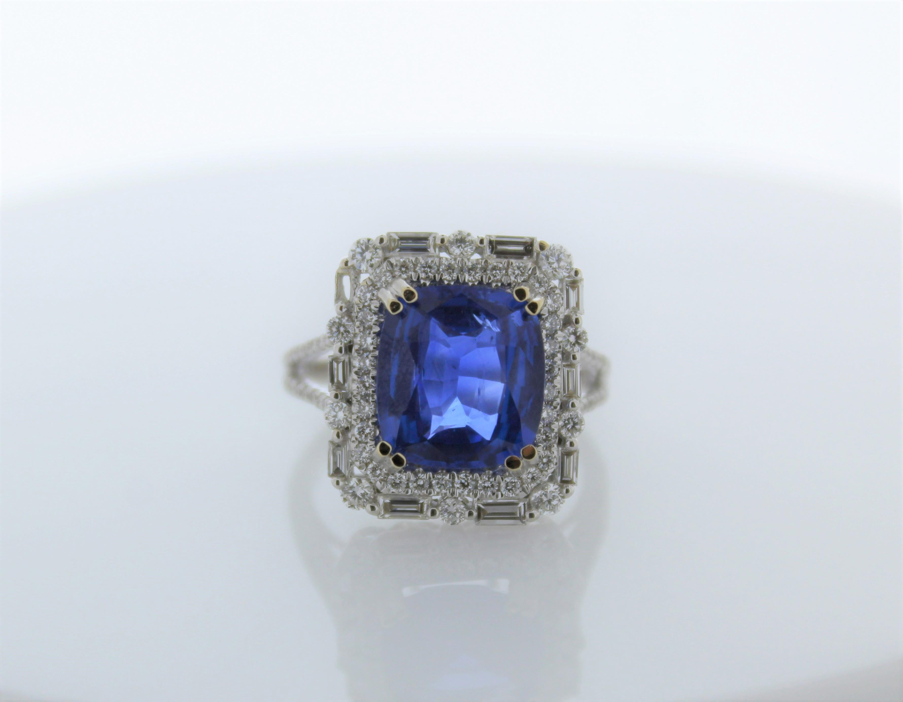 This gorgeous ring showcases a cushion cut blue sapphire that weighs 4.53 carats. It is surrounded by 91 diamonds that total up to 1.85 carats. Set in 18K White Gold. 
