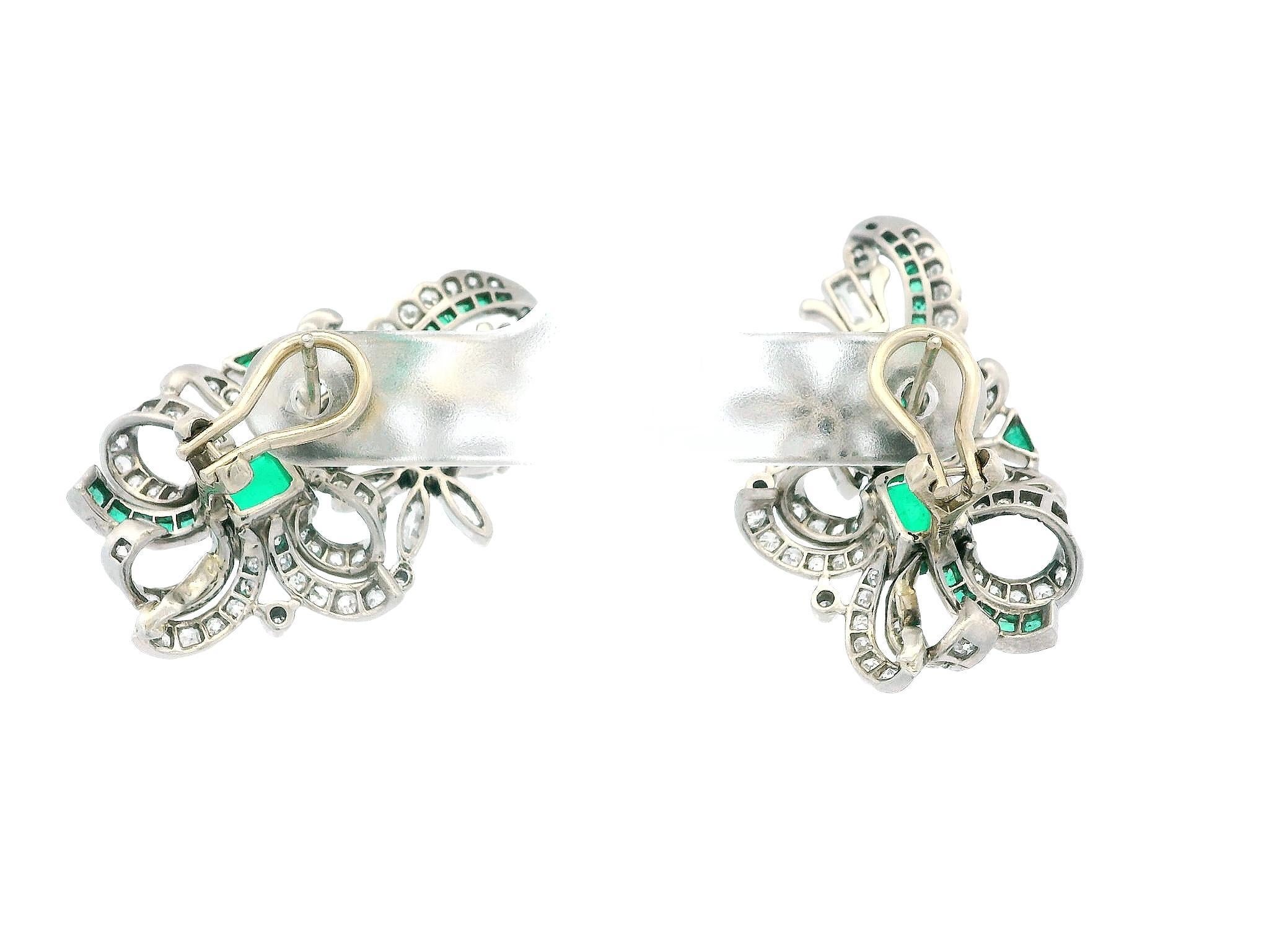 Estos exquisitos pendientes vintage presentan un motivo de lazo que realza las esmeraldas engastadas. Las esmeraldas tienen un peso combinado de aproximadamente 1,90 quilates y son transparentes, mostrando un tono verde brillante y saturado.

El