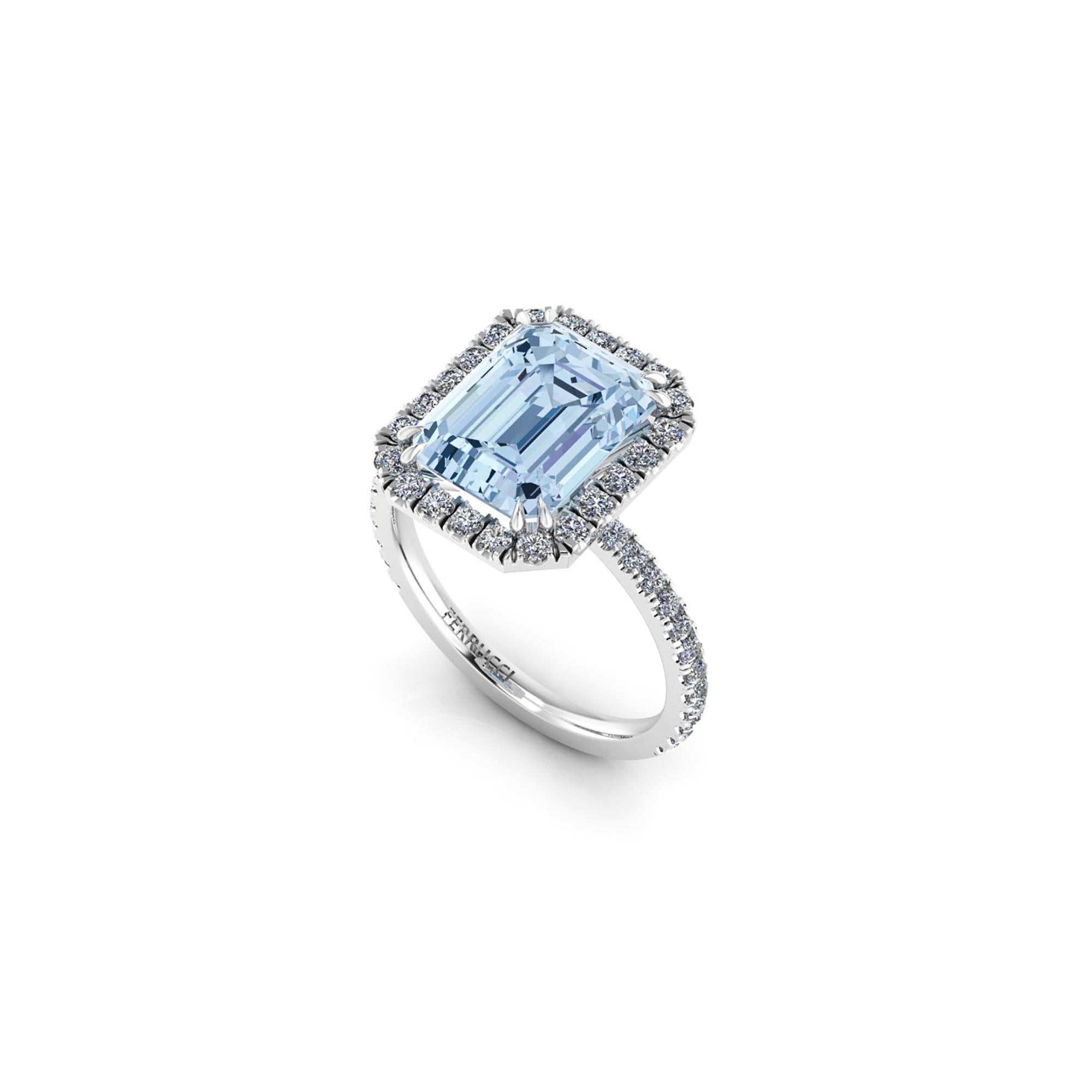An exquisite 4.54 carat Aquamarine, emerald cut, very high quality color, eye clean gem, set with double claw prongs, embellished by a Halo of bright diamonds of approximately  total carat weight of 0.65 carat, set in an hand crafted, delicate and
