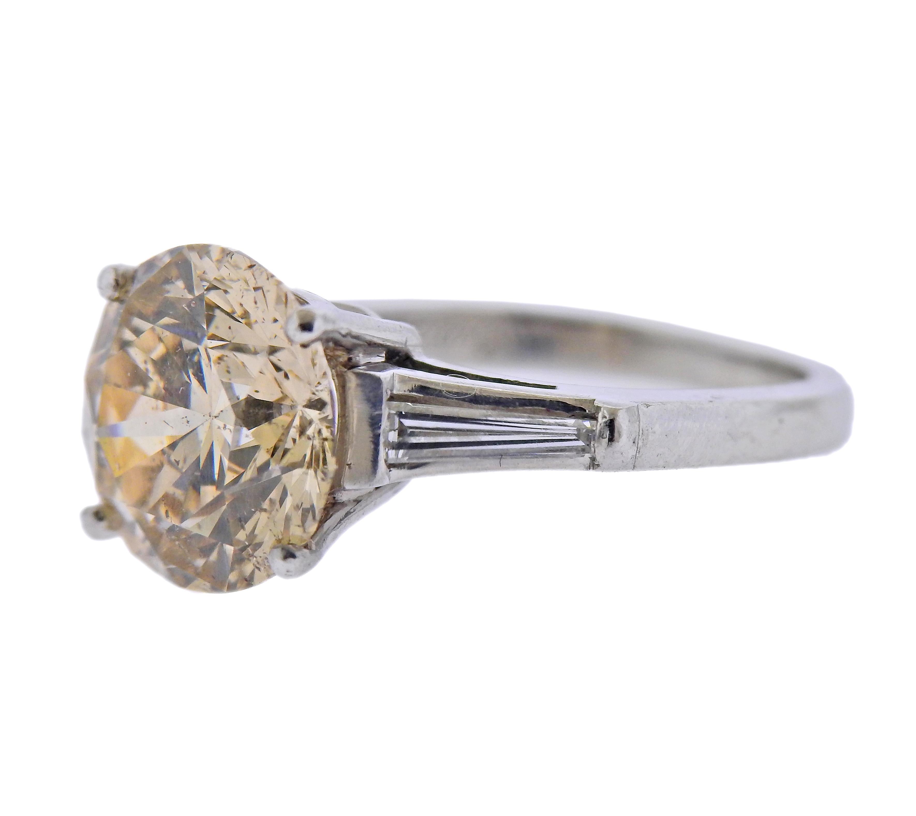 Long's platinum engagement ring, set with center 4.55ct faint brown diamond, set with two tapered baguettes on sides. Ring size - 5. Marked: Long's, pt900. Weight - 7 grams.