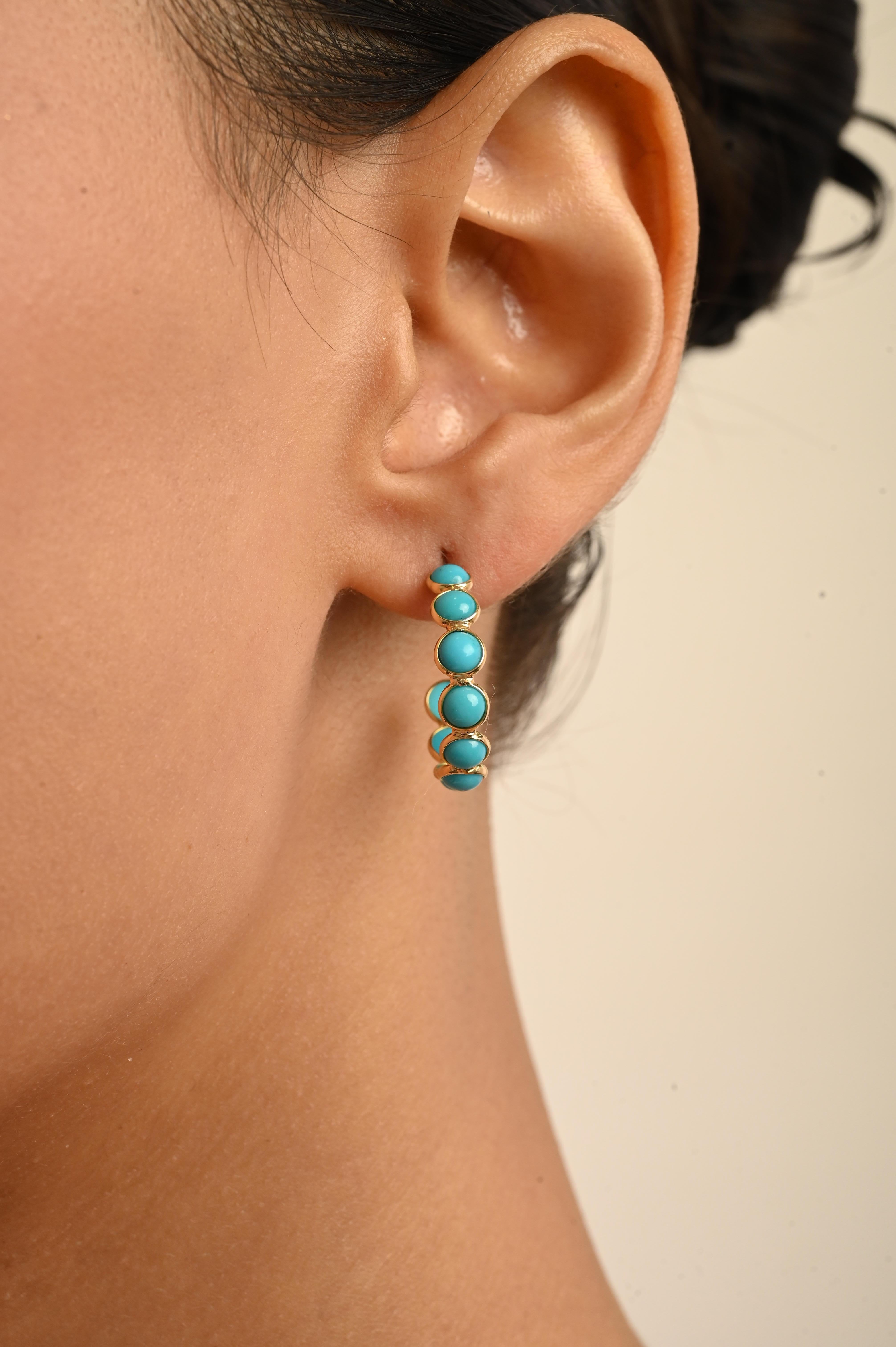 Questi eleganti orecchini a cerchio sono realizzati in oro giallo 18 carati e presentano gemme turchesi rotonde con taglio cabochon per un peso totale di 4,55 carati. Ogni turchese è incastonato in un design circolare aperto che mette in risalto il