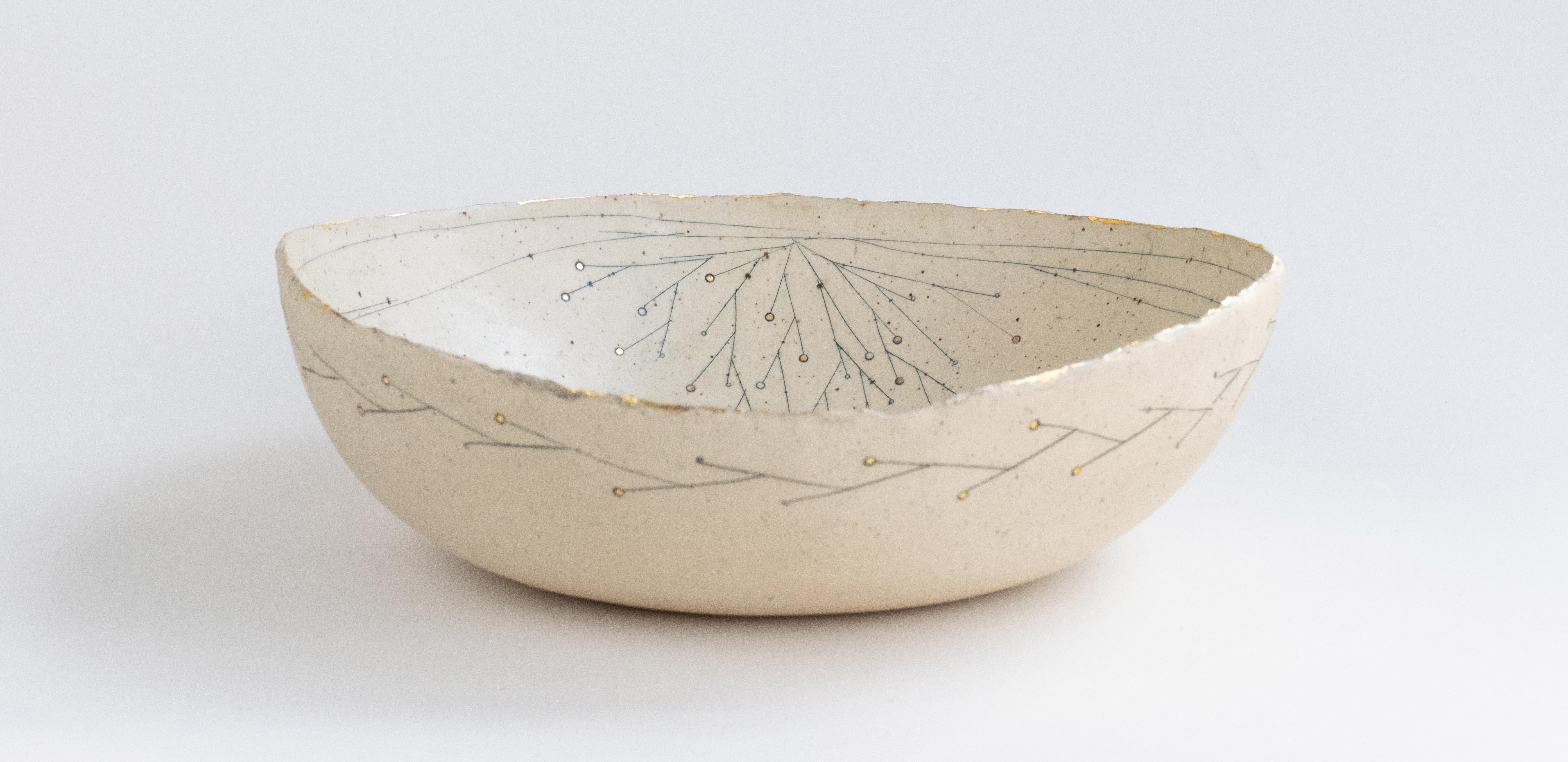 Un delicado cuenco hecho a mano, de forma orgánica con un borde de arcilla rasgada en arcilla de gres moteada natural.
Forma parte de la Serie Promesa Dorada, un tema de elementos abstractos y estilizados de la naturaleza. Este cuenco tiene