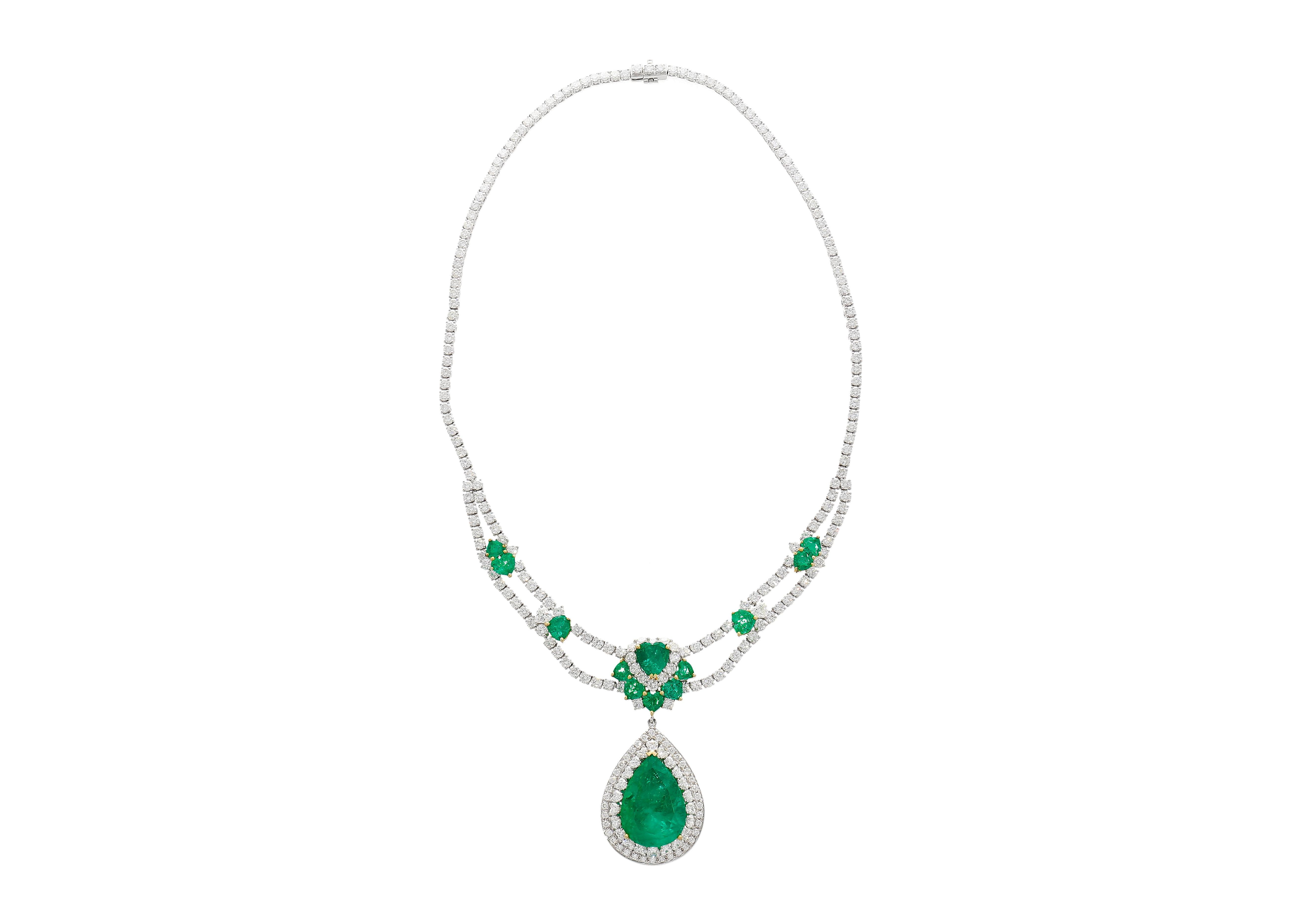 45.58 Carat total chandelier drop necklace in 18k white gold. Featuring a GRS certified 18.82 carat Colombian emerald center stone with adorning heart cut emeralds and diamonds. Fixed on a tennis necklace chain that echoes a symbol of sophistication
