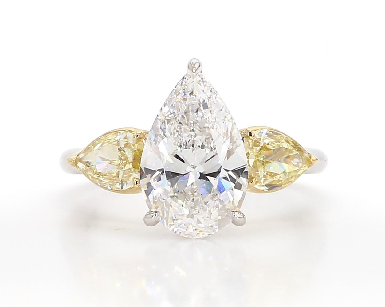 Novel Collection showcasing a unique and elegant engagement ring, At its heart lies a stunning 3.12 carat pear-shaped diamond, GIA certified as E color and VS1 in clarity. This captivating centerpiece is complemented by two Fancy Yellow diamonds