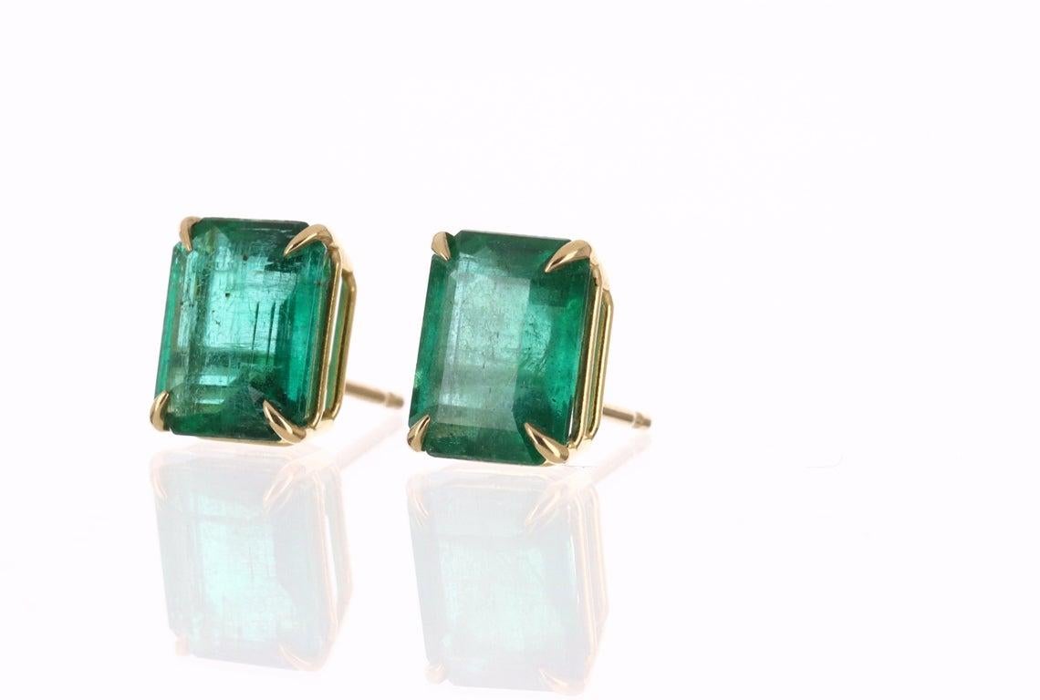 Featured here is a beautiful set of emerald cut, Zambian emerald studs in fine 18K yellow gold. Displayed are deep-green emeralds with very good transparency, accented by elegant claw prongs, allowing for the emerald to be shown in full view. The