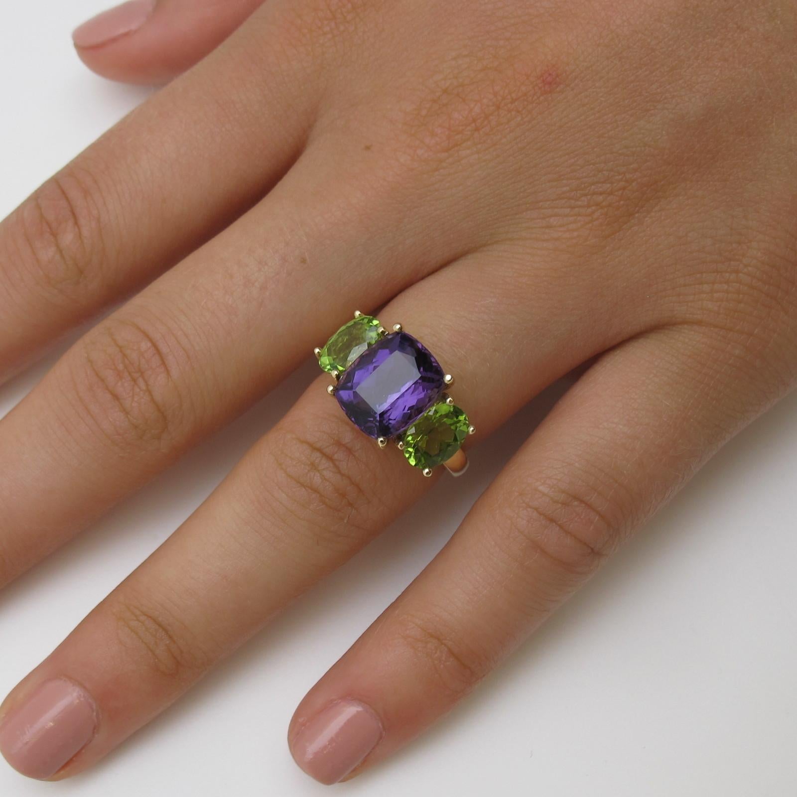 This particular ring is truly a show stopper! With its distinctive color pairing, it sure to put a smile on your face! Its cushion cut amethyst measuring 11.94x6.74mm and weighing 4.56 carats and two oval peridot measuring 8x6mm and weighing 2.74